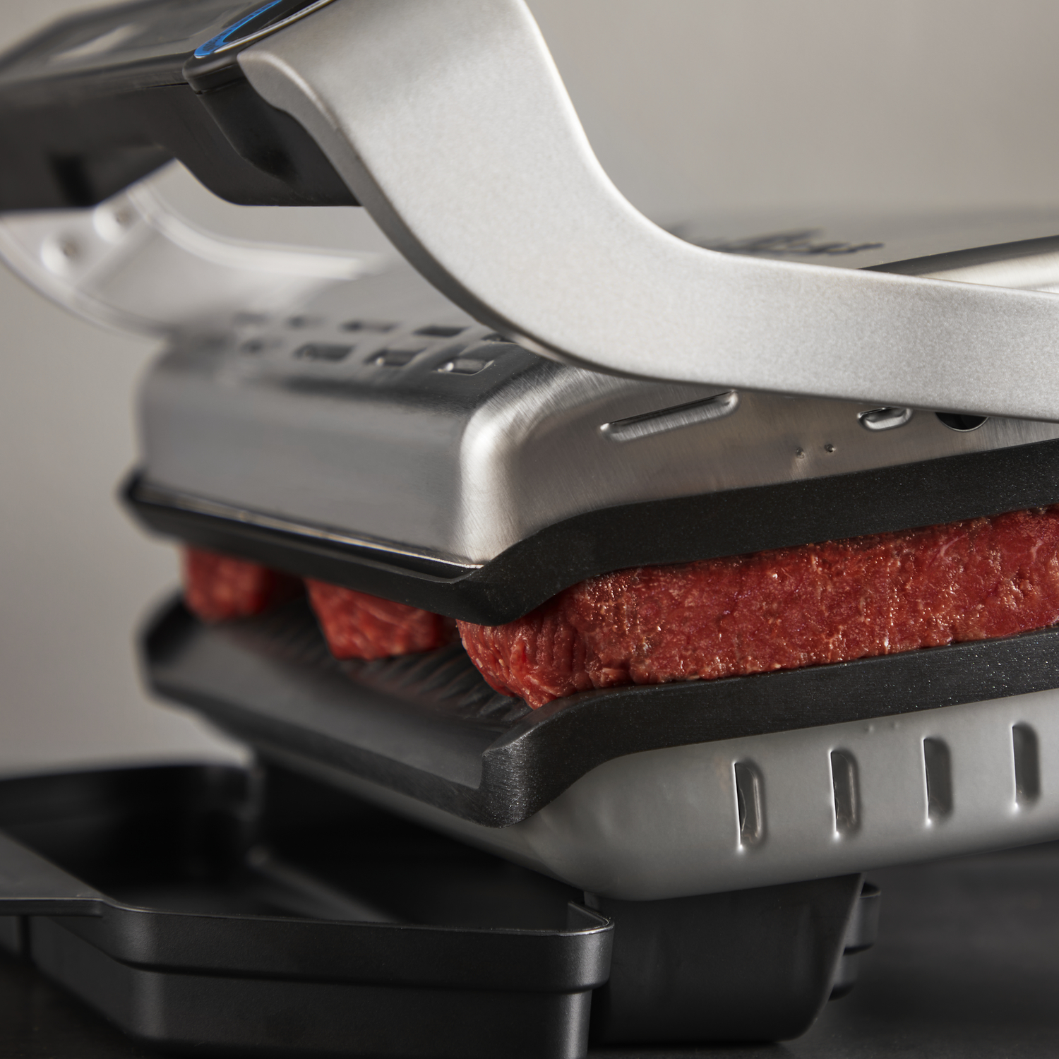 Grill with two steaks on the inside. The grill is open.