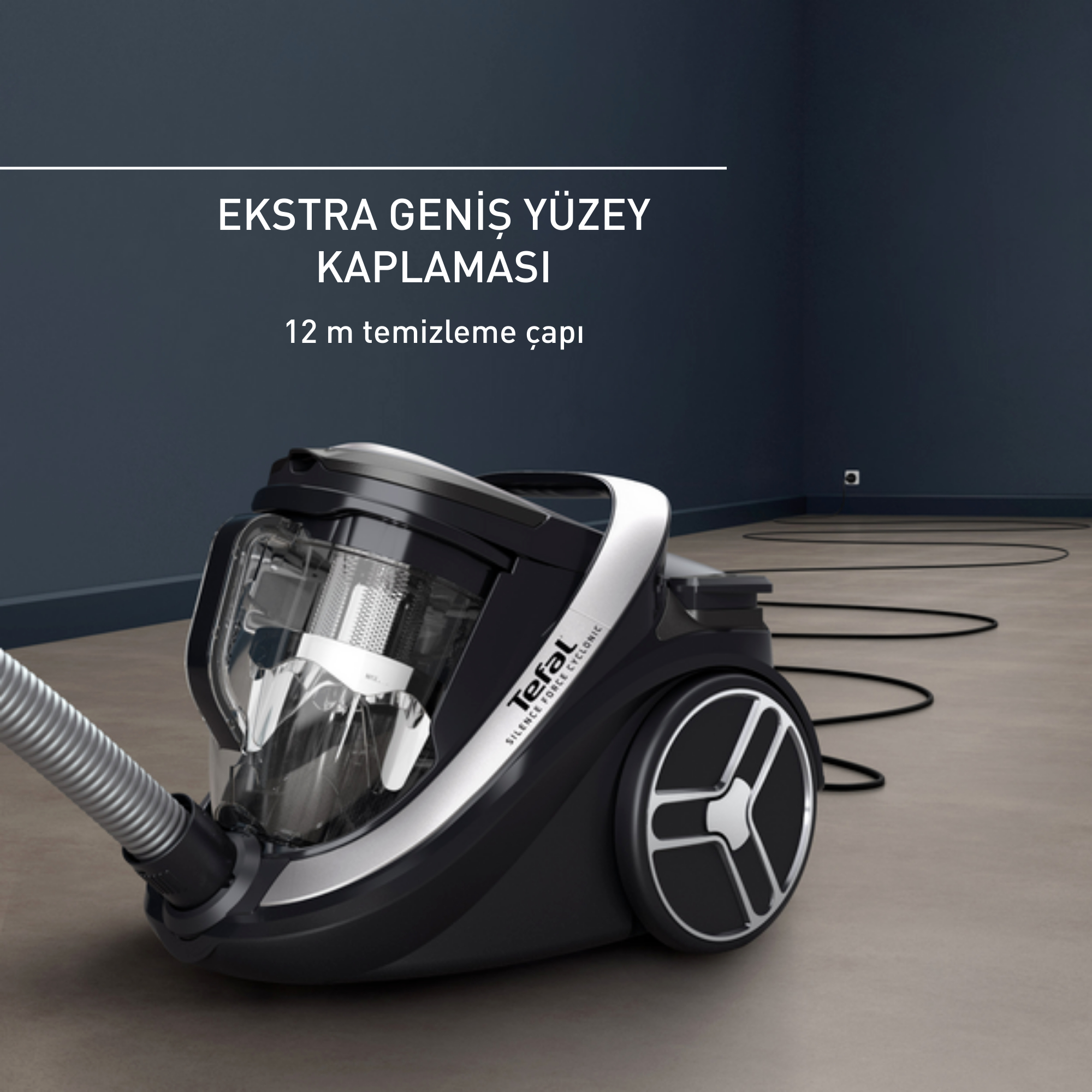 Bir zeminde siyah beyaz bir elektrikli süpürge, şu metinle birlikte: Ekstra geniş yüzey kapsamı.