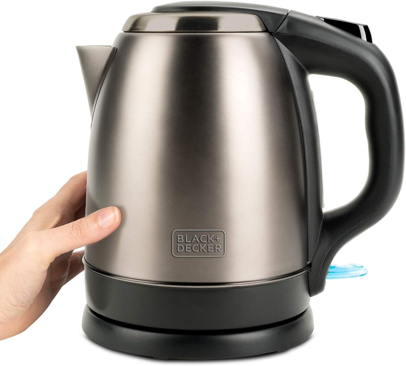 Srebrno-czarny czajnik elektryczny. Ręka sięga po uchwyt.