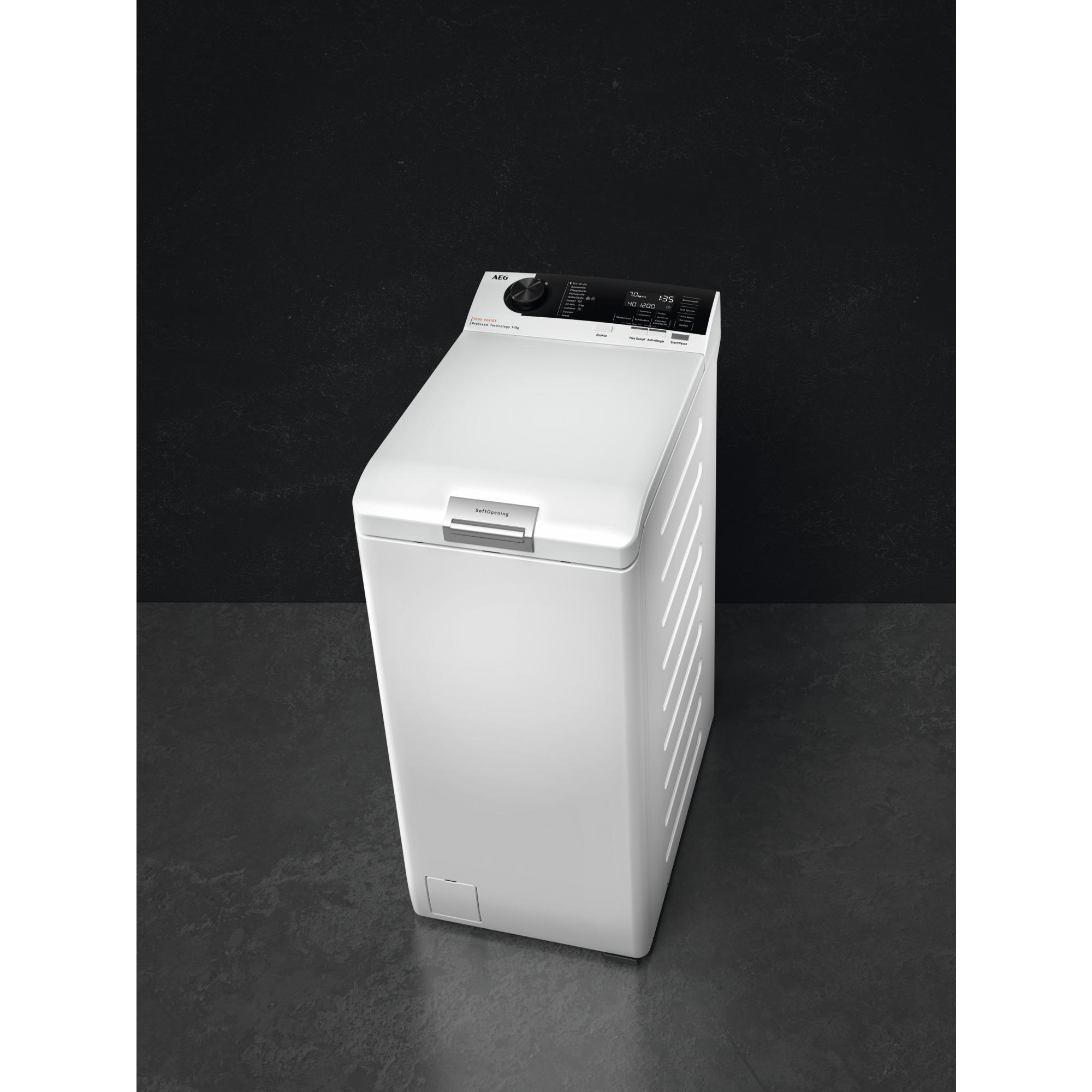 Weiße Waschmaschine auf dunklem, grauem Boden vor schwarzer Wand.