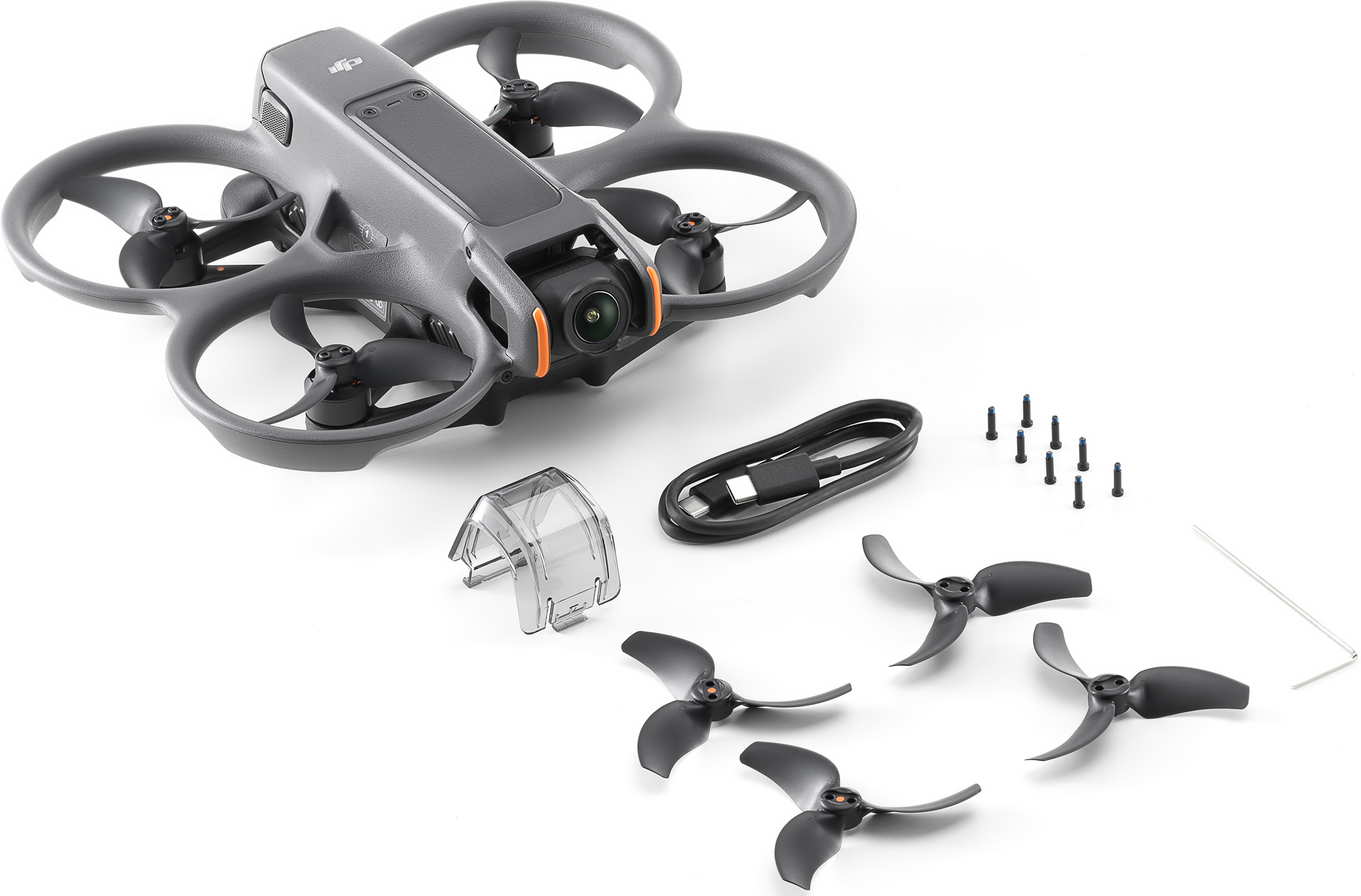 Drone grigio con eliche, fotocamera, batteria e accessori su una superficie bianca.