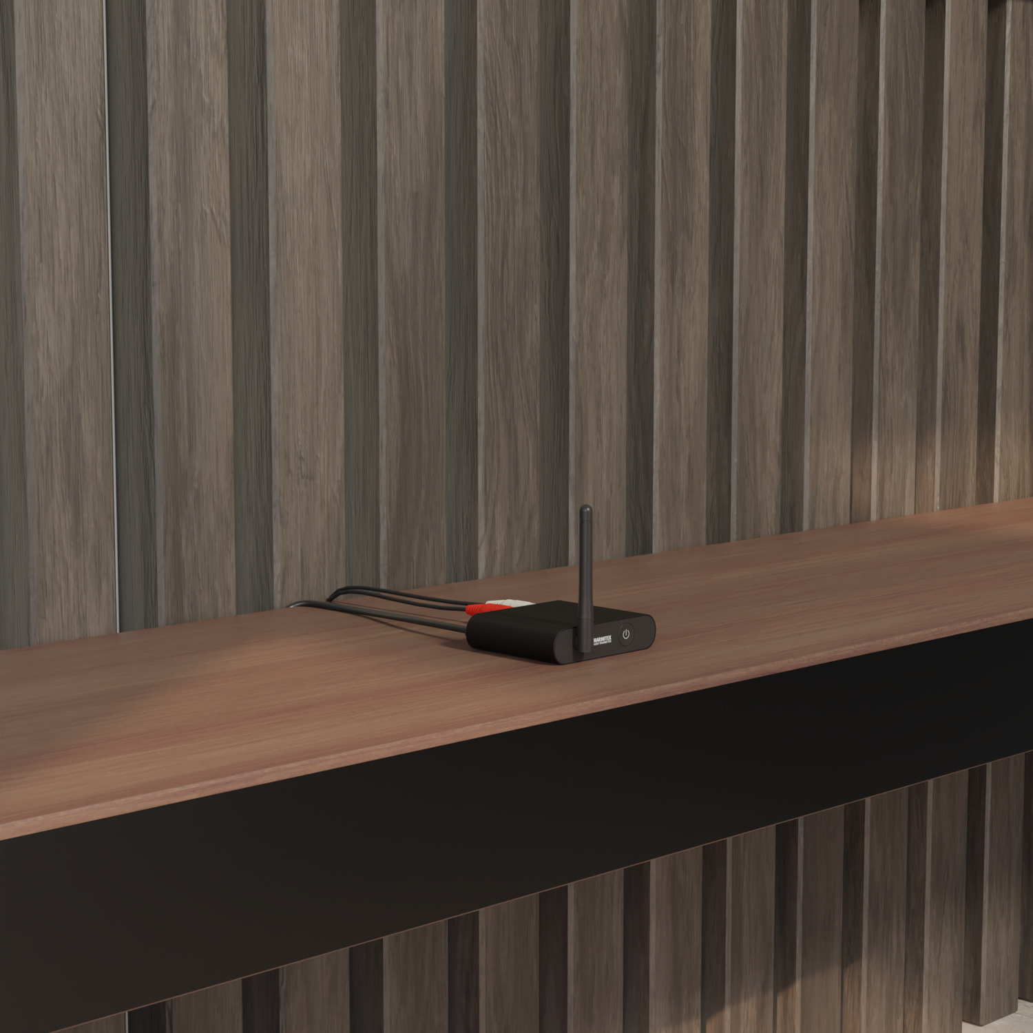 A black device with an antenna, connected by cables, on a wooden surface.