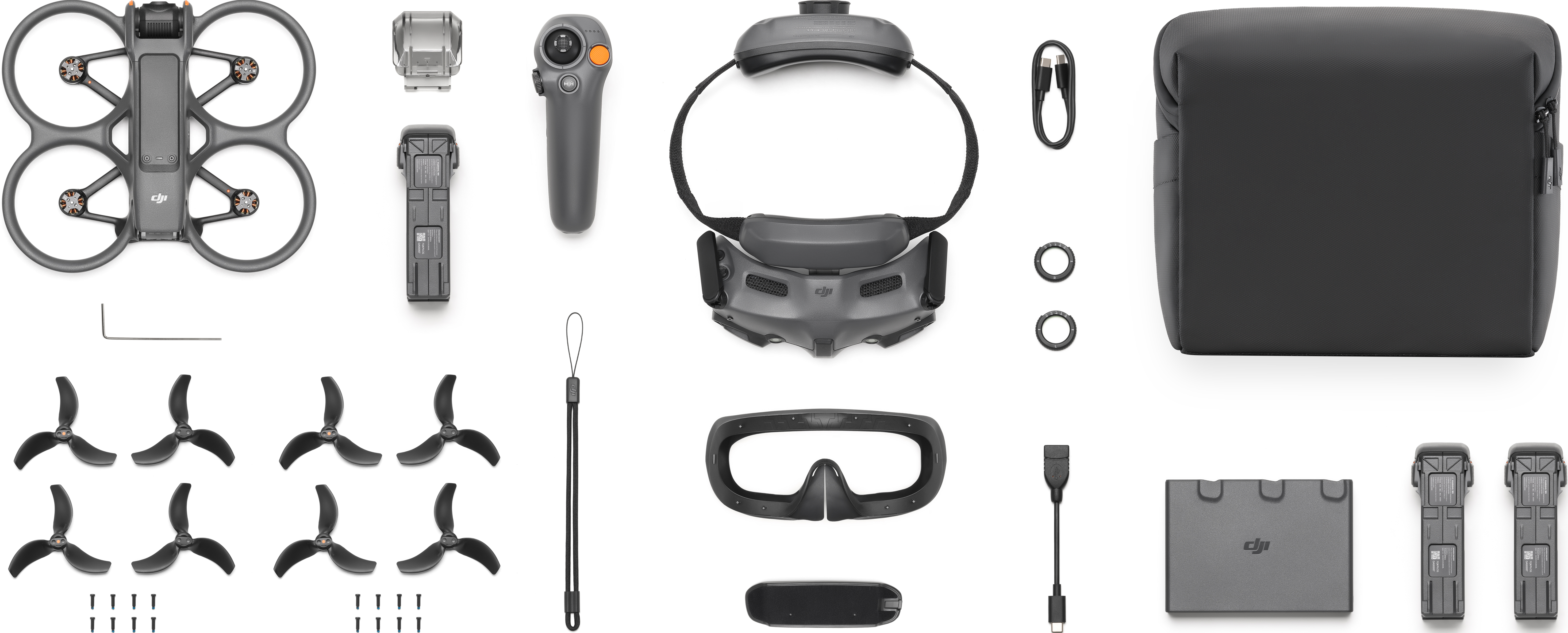 Drone e accessori disposti su superficie bianca.