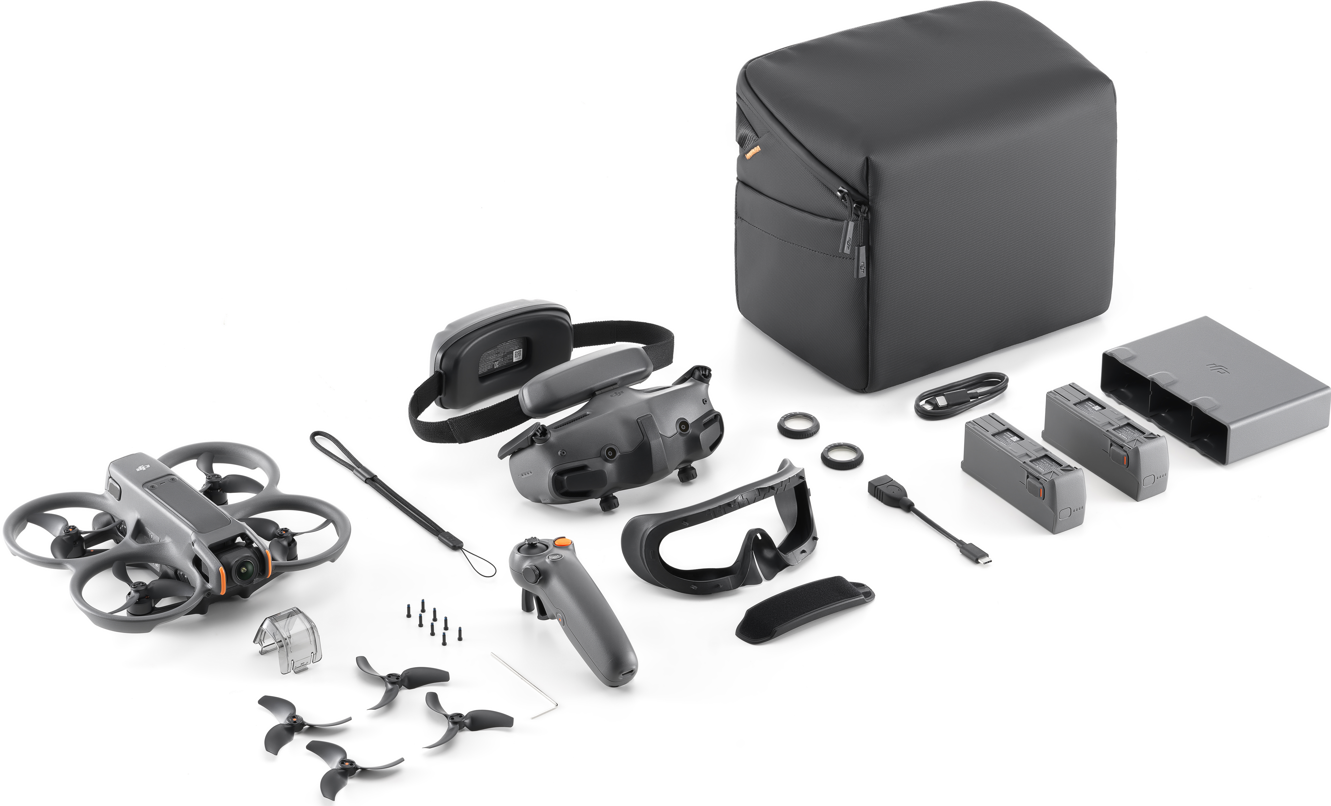 Kit drone con drone, controller, occhiali, batterie, custodia e accessori su bianco.