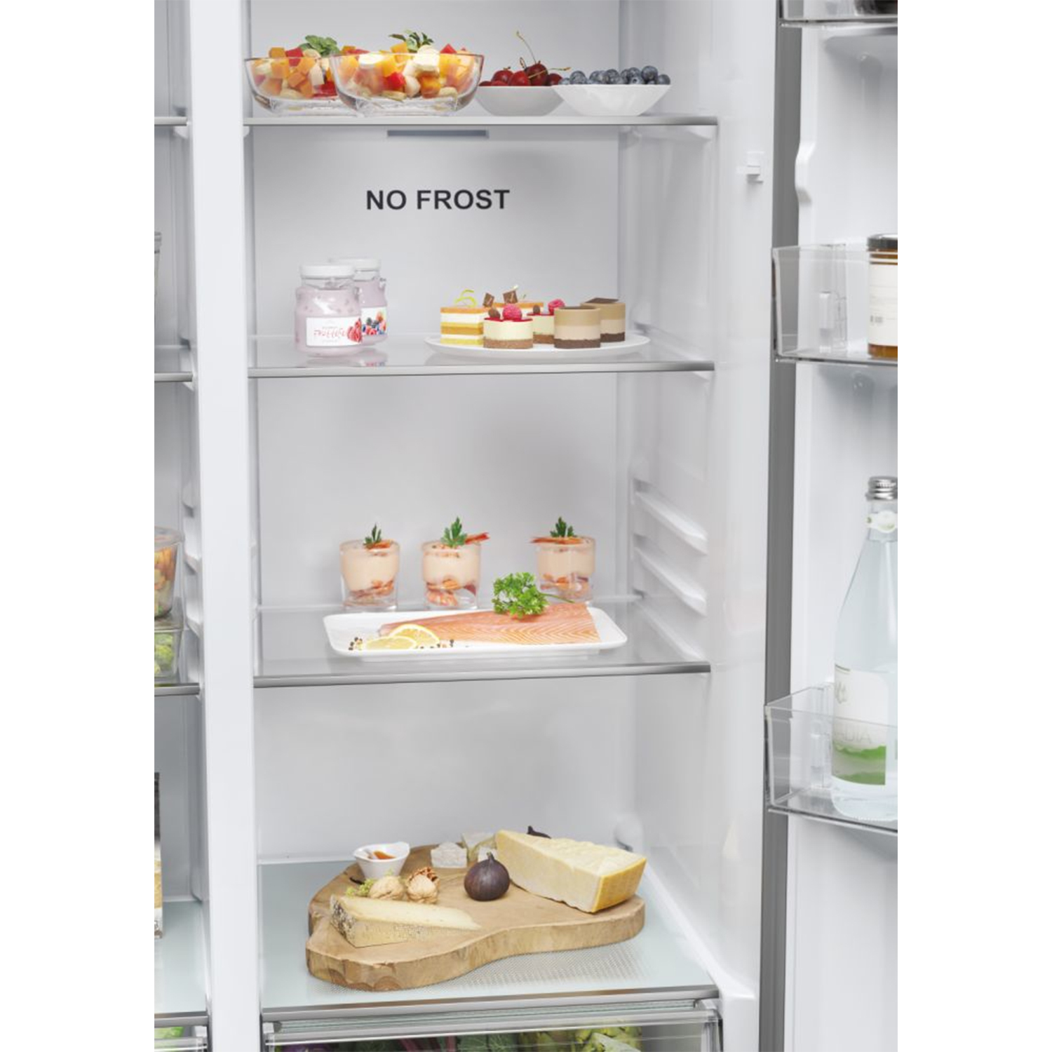 Interno di un frigorifero con vari alimenti sugli scaffali, etichettato 'NO FROST'.