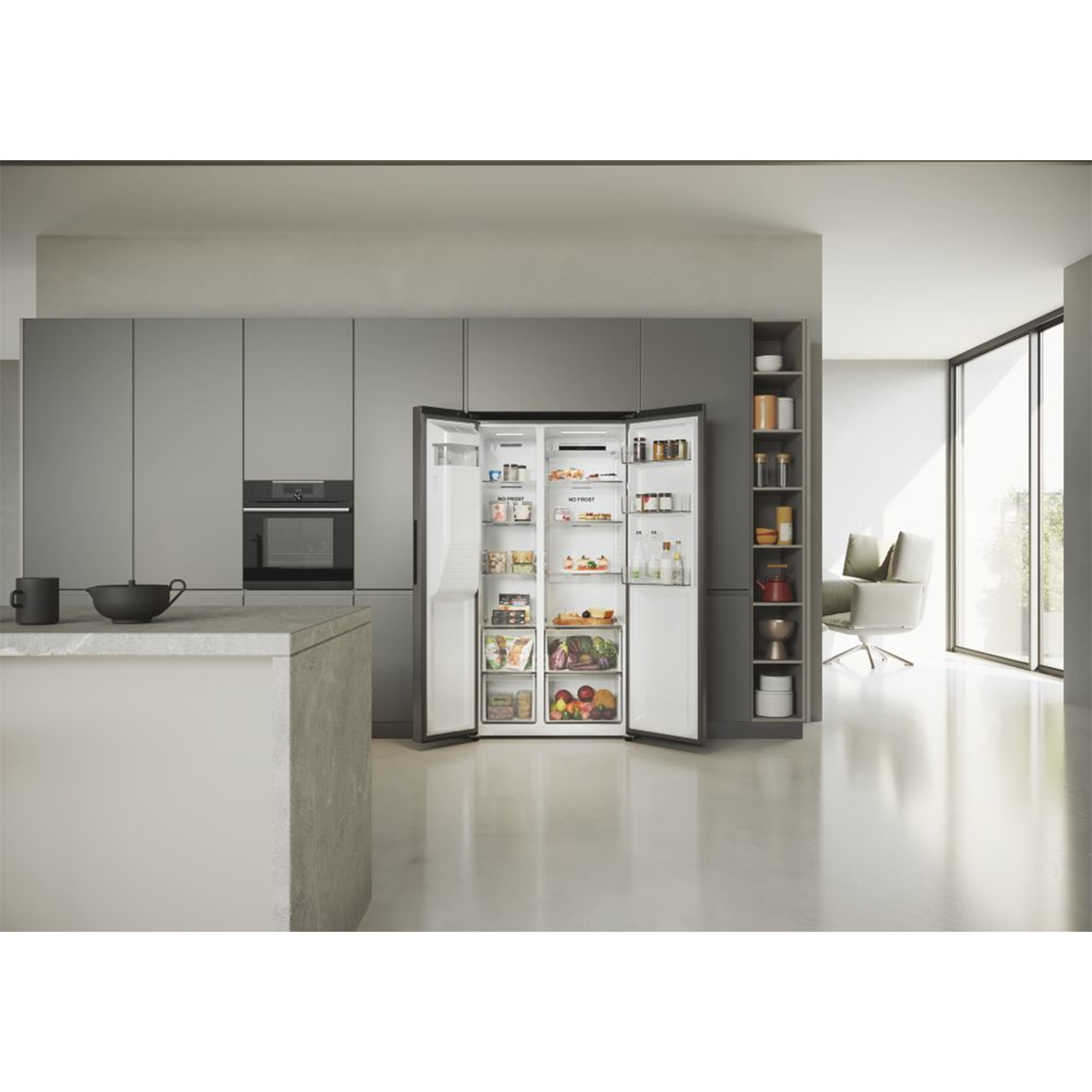 Cucina moderna con un grande frigorifero a porta aperta. Armadi grigi, isola cucina e una sedia visibili.