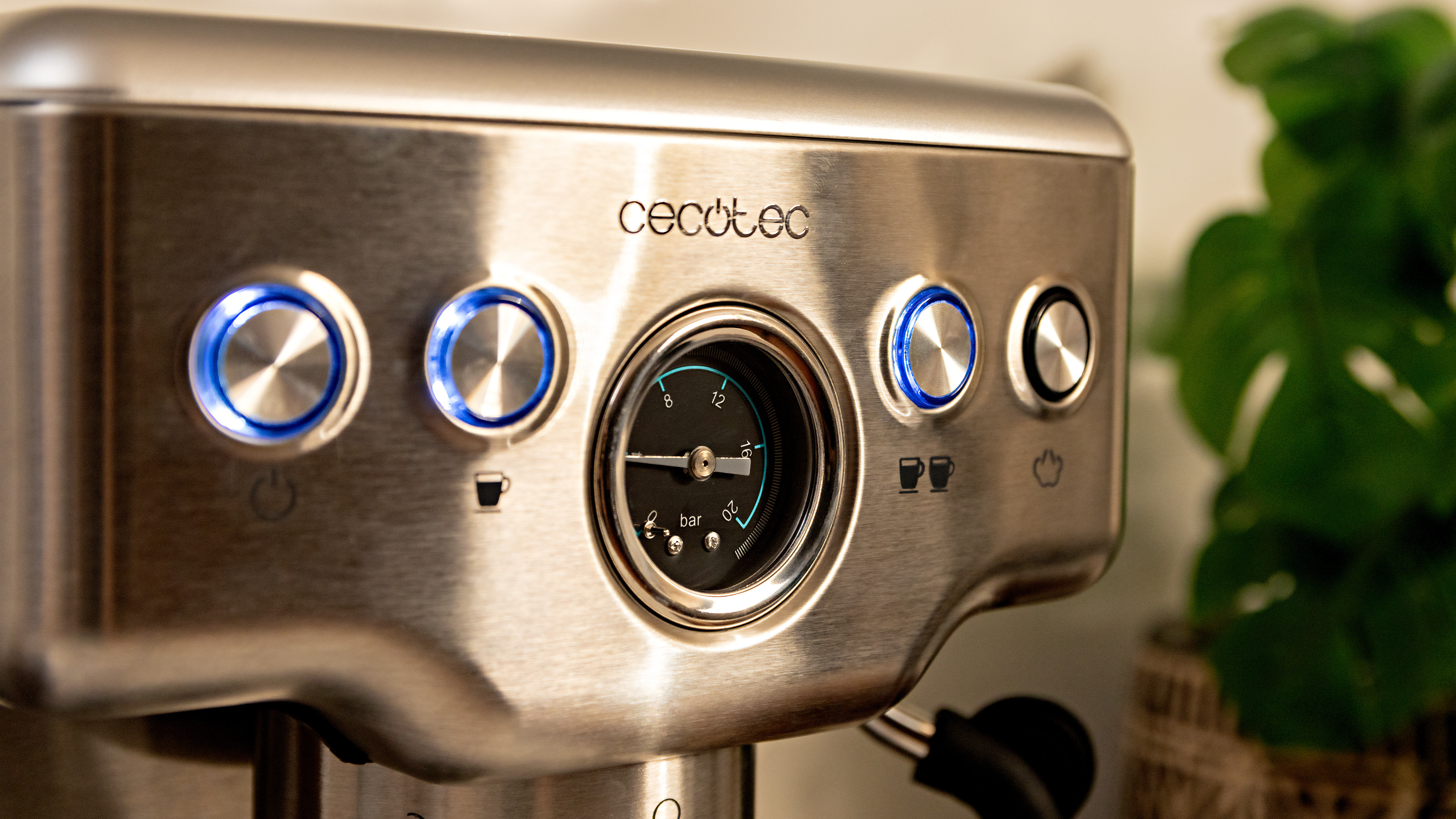 Primer plano de una máquina de espresso de acero inoxidable. Los botones son azules.