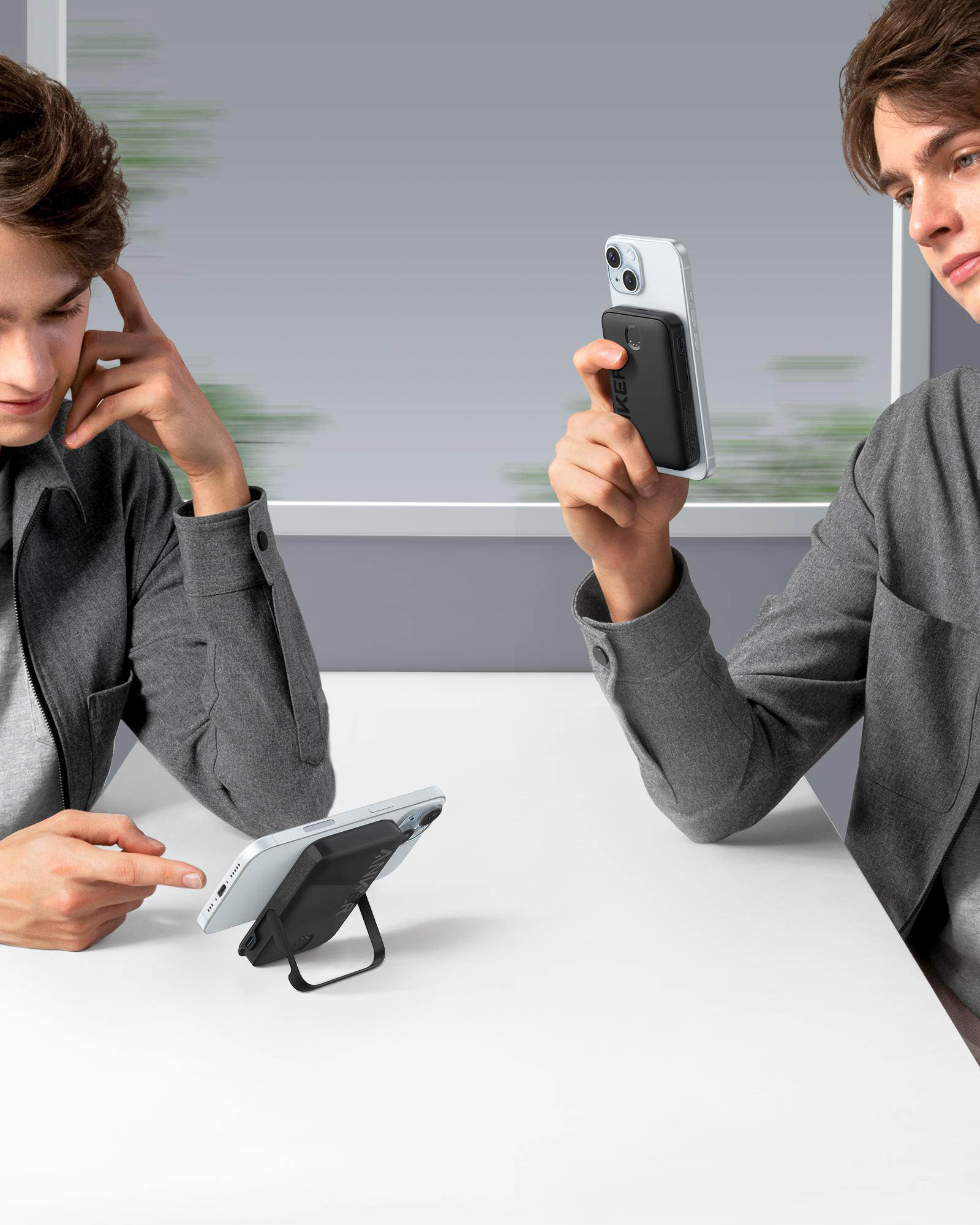 Zwei Männer interagieren mit Handys. Einer hält ein Handy mit Ständer und Ladegerät.