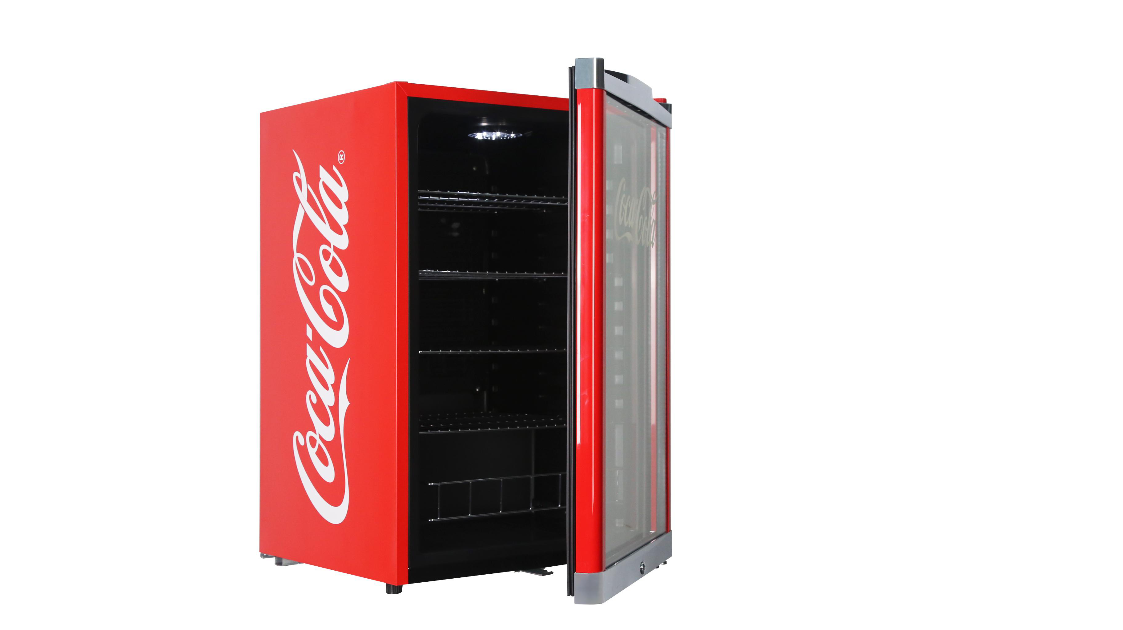 Roter Coca-Cola Mini-Kühlschrank, offene Tür, schwarzer Innenraum, weißer Hintergrund.