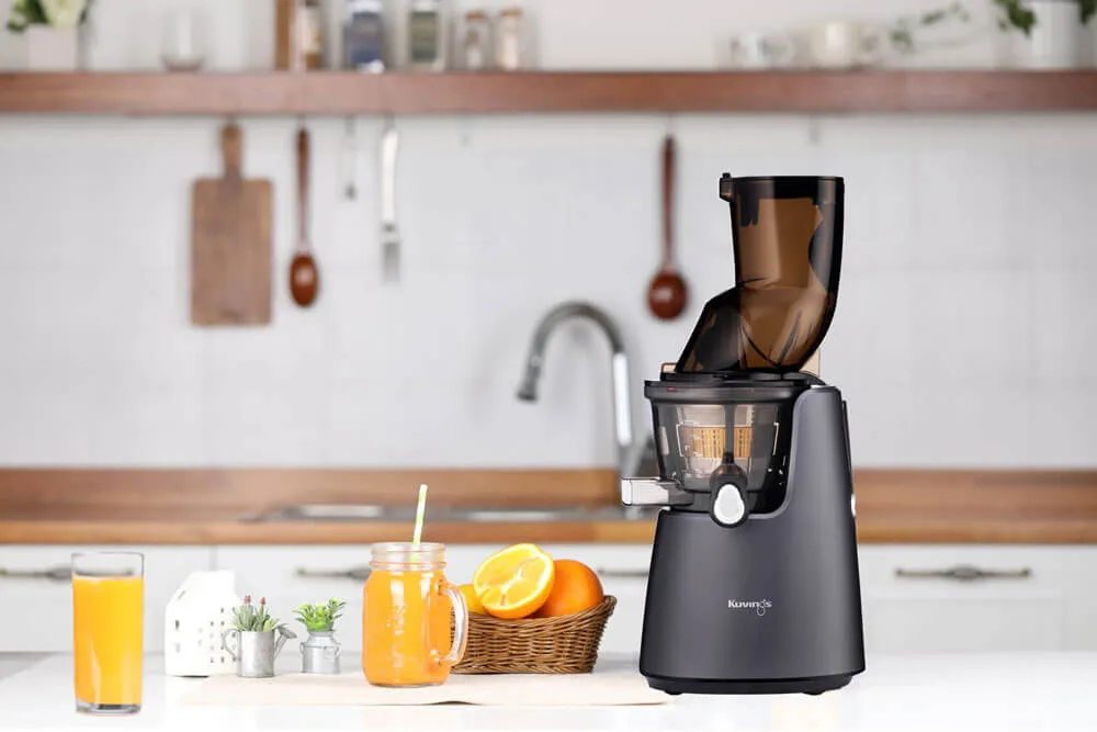 Wyiskarka i składniki soku pomarańczowego na blacie kuchennym.