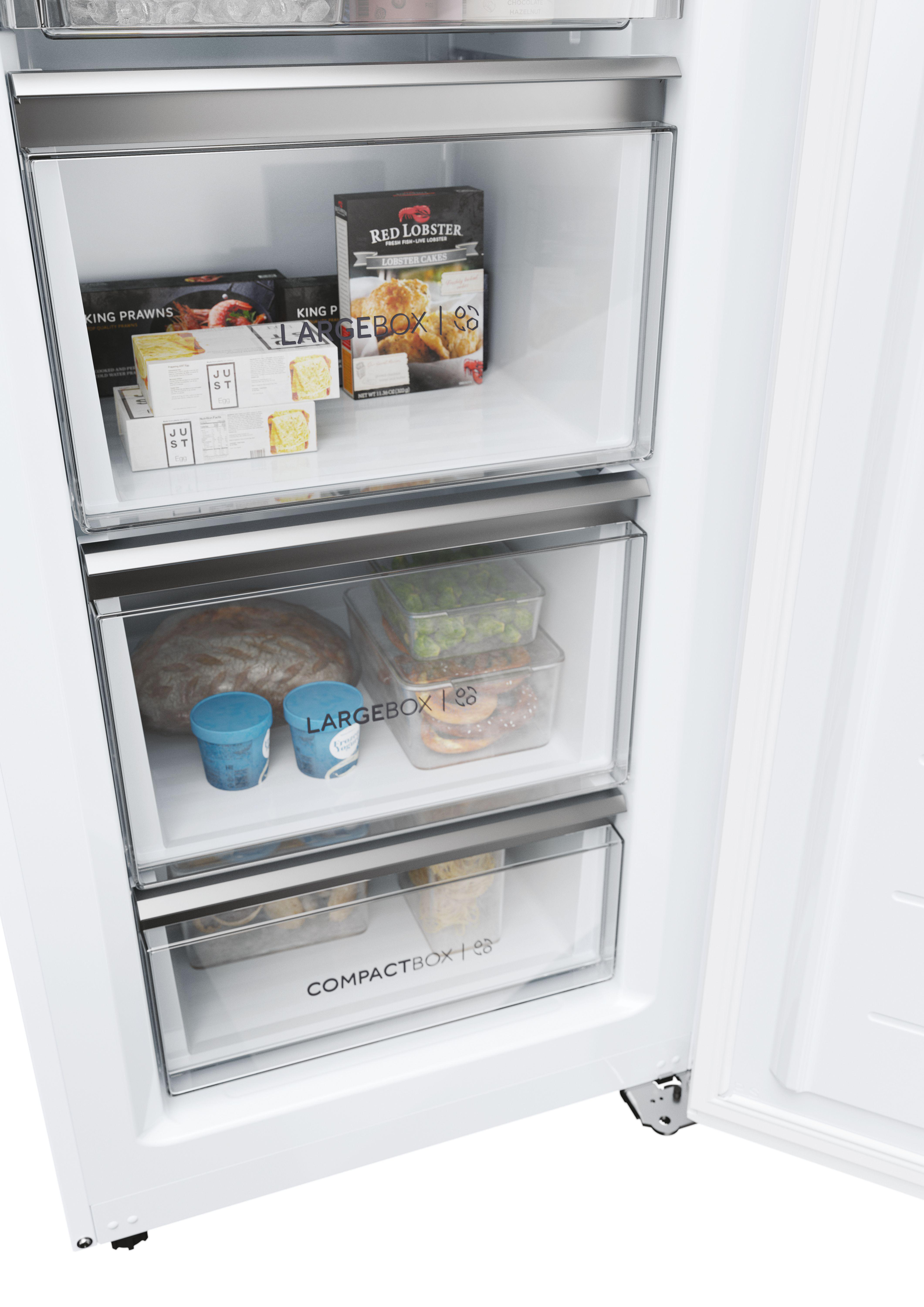Geöffneter Kühlschrank mit Schubladen, die Lebensmittel enthalten.
