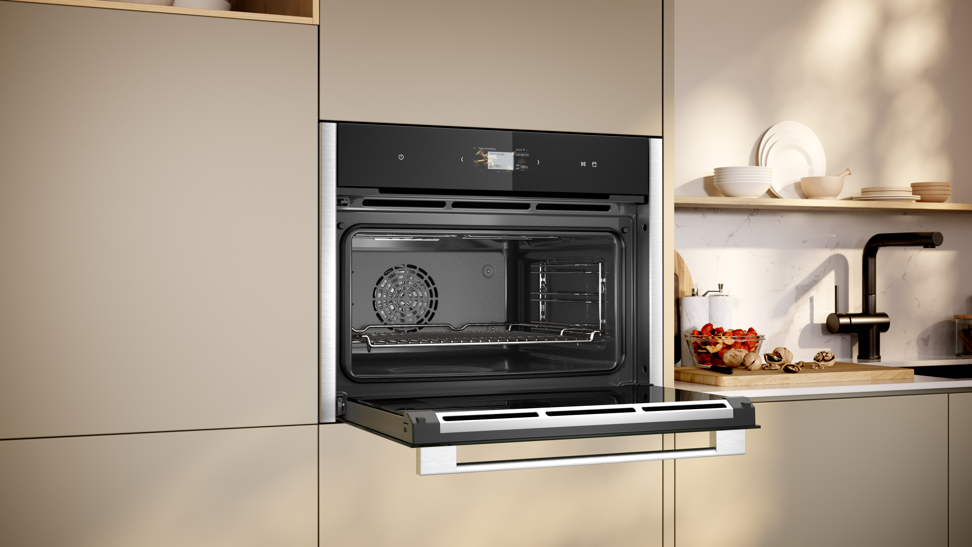 Ein offener Backofen in einer Küche. Er hat ein Display und einen Ventilator im Inneren.