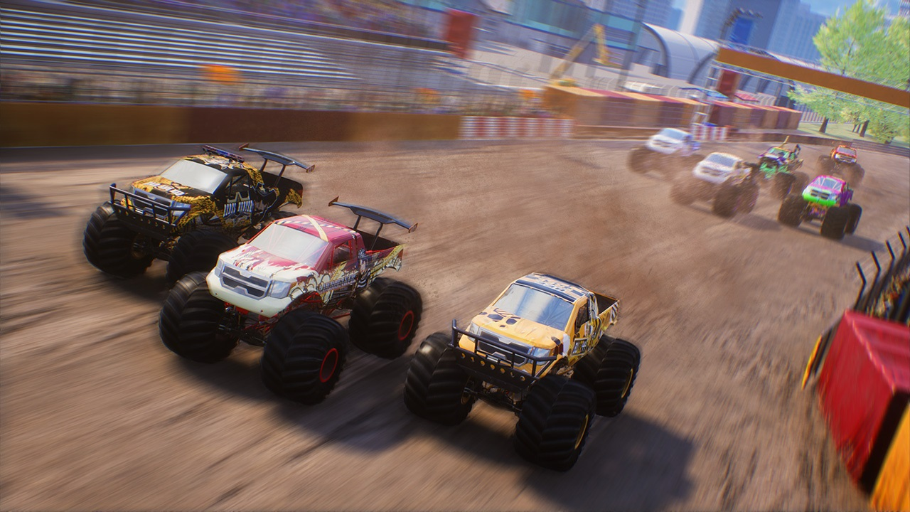Monster truck che corrono su una pista sterrata. Tre in primo piano, altri sullo sfondo, con vista sulla città.