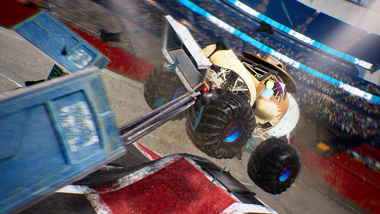 Monster truck in un'arena, che si schianta contro un bagno portatile, con detriti.