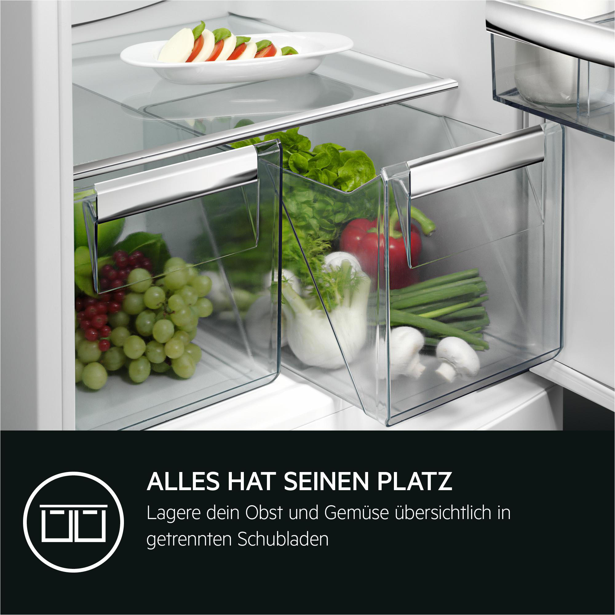 Kühlschrankinnenraum mit Obst und Gemüse in durchsichtigen Schubladen, weißen Regalen und einem Teller mit Salat.