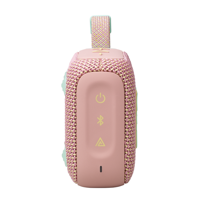 Un altavoz portátil JBL rosa. Tiene botones de control y una correa de tela.