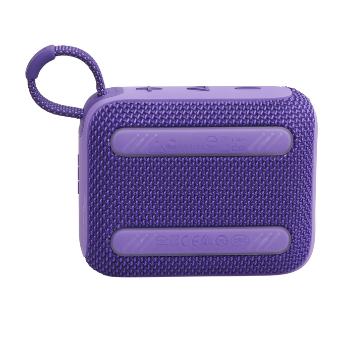Altavoz portátil púrpura. Tiene una textura tejida con botones en la parte superior.