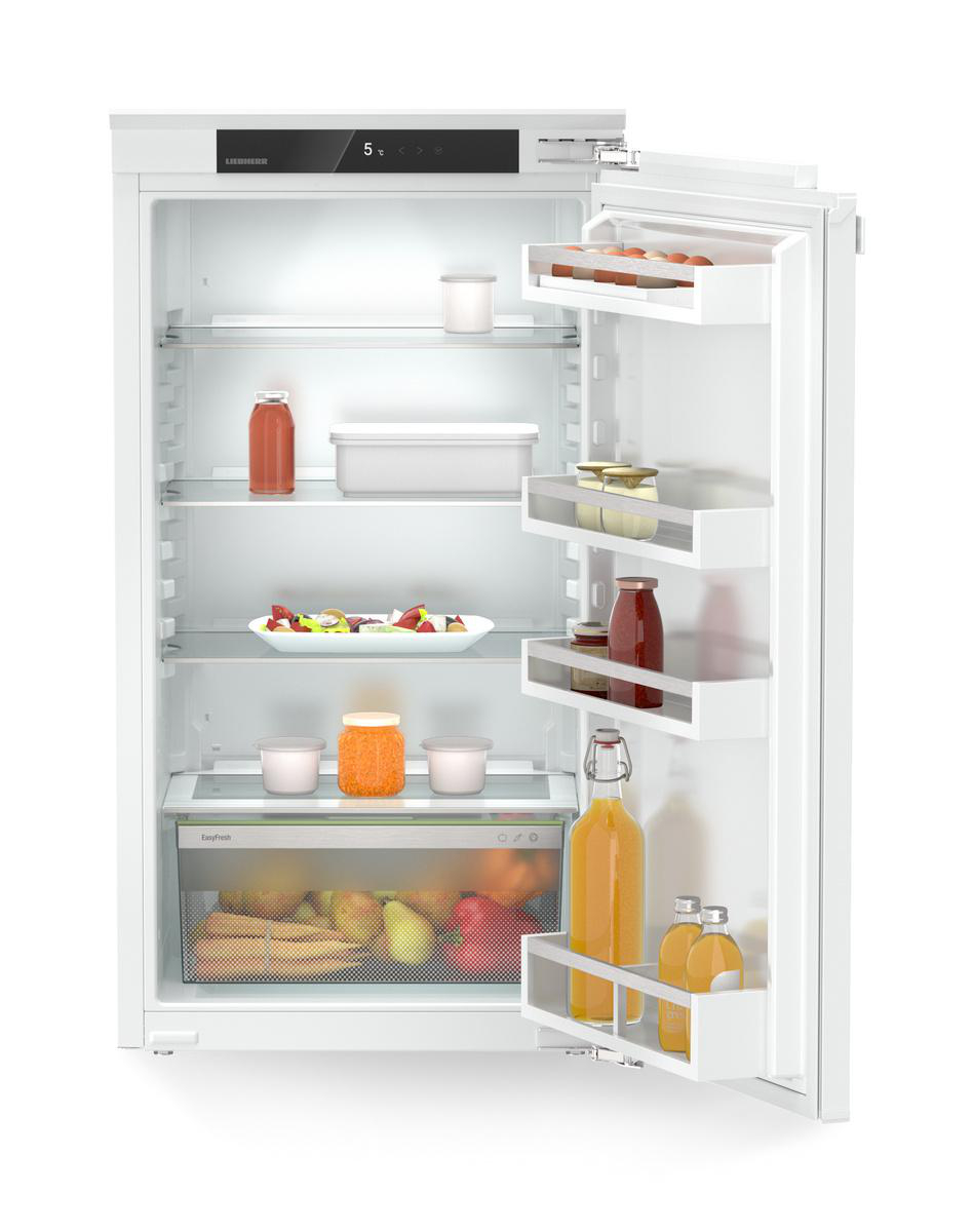Geöffneter weißer Kühlschrank mit Lebensmitteln, darunter Flaschen, Gläser und frische Produkte.