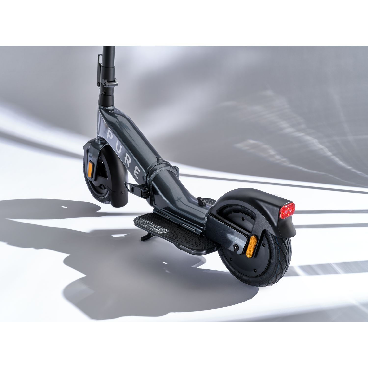 Une trottinette électrique grise avec un guidon noir et un feu arrière, sur fond blanc.
