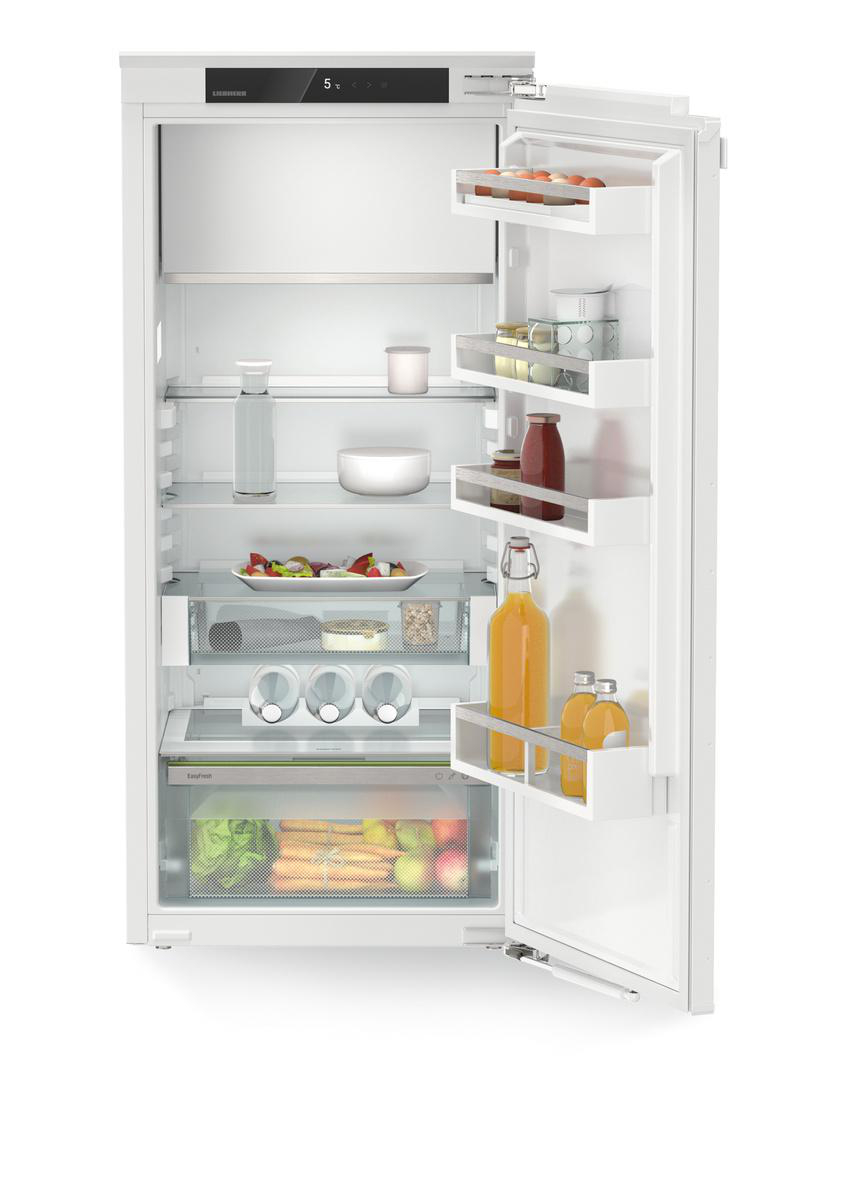 Ein weißer Kühlschrank mit offener Tür. Innen Regale mit Lebensmitteln und Flaschen. Weißer Hintergrund.