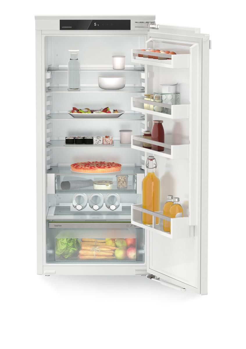 Ein weißer Kühlschrank, offen, mit Regalen voller Essen und Getränke auf weißem Hintergrund.