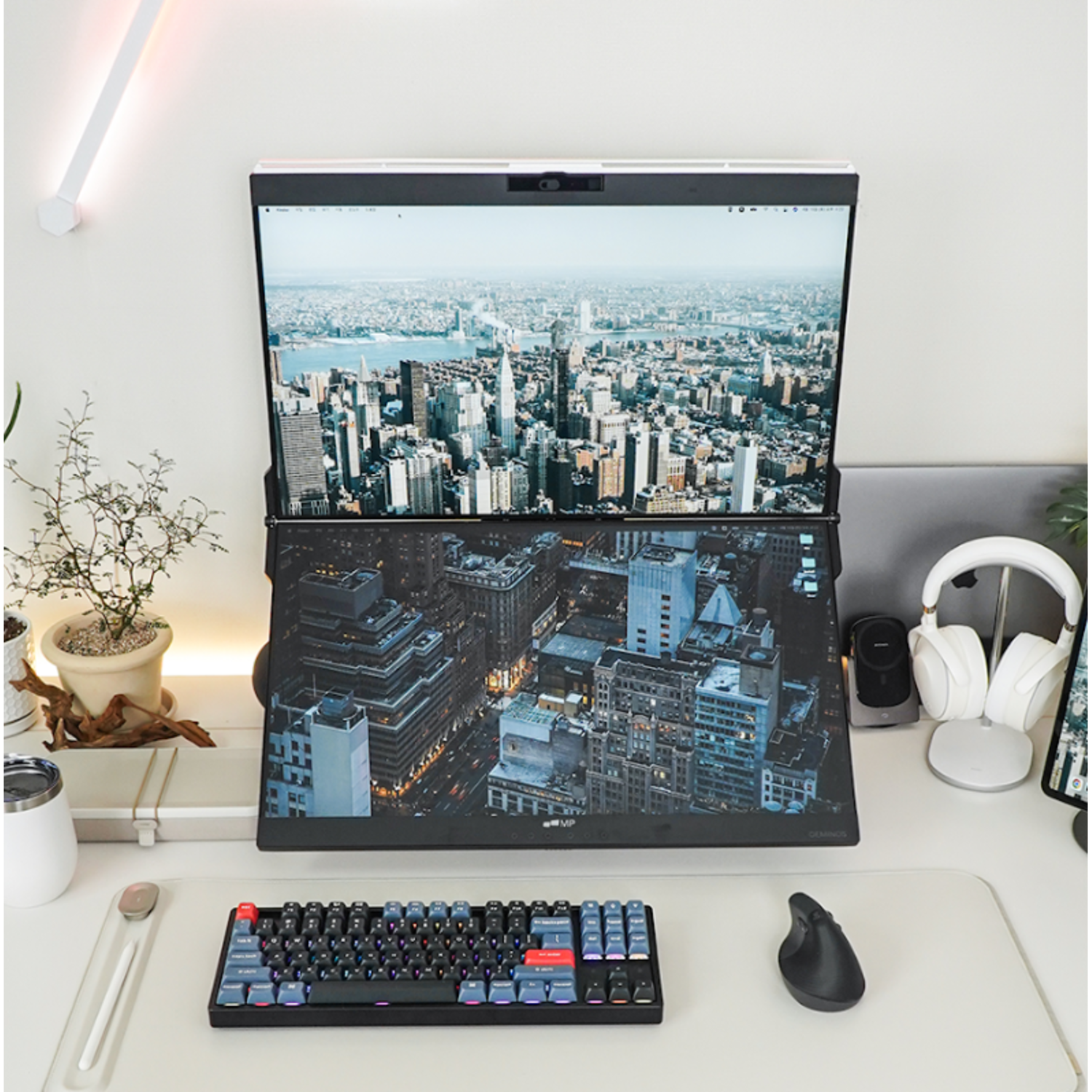 A modern desk setup with two monitors, keyboard, mouse, and headphones.