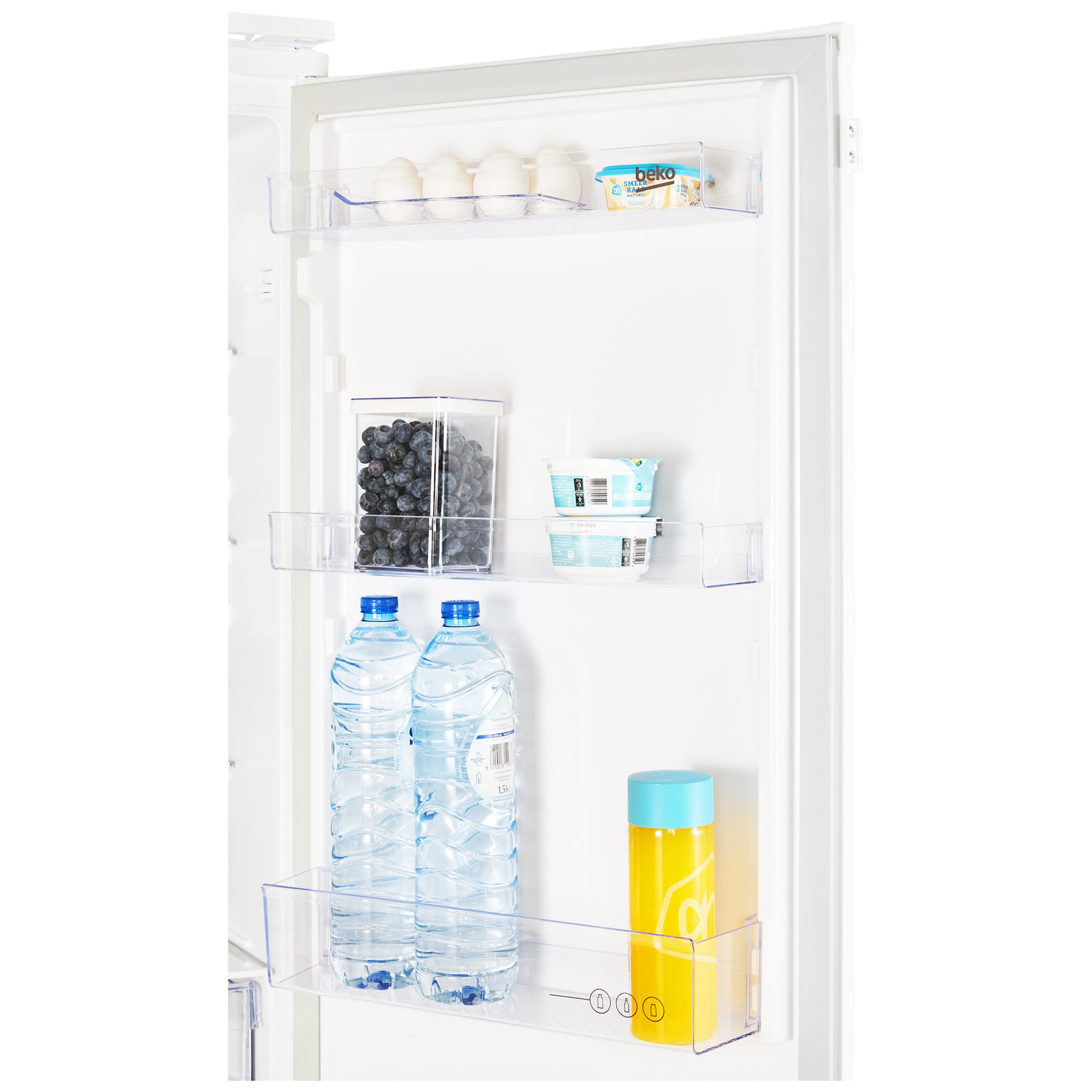 Interior of a refrigerator. Contains water bottles, juice, eggs, yogurt, and blueberries.
