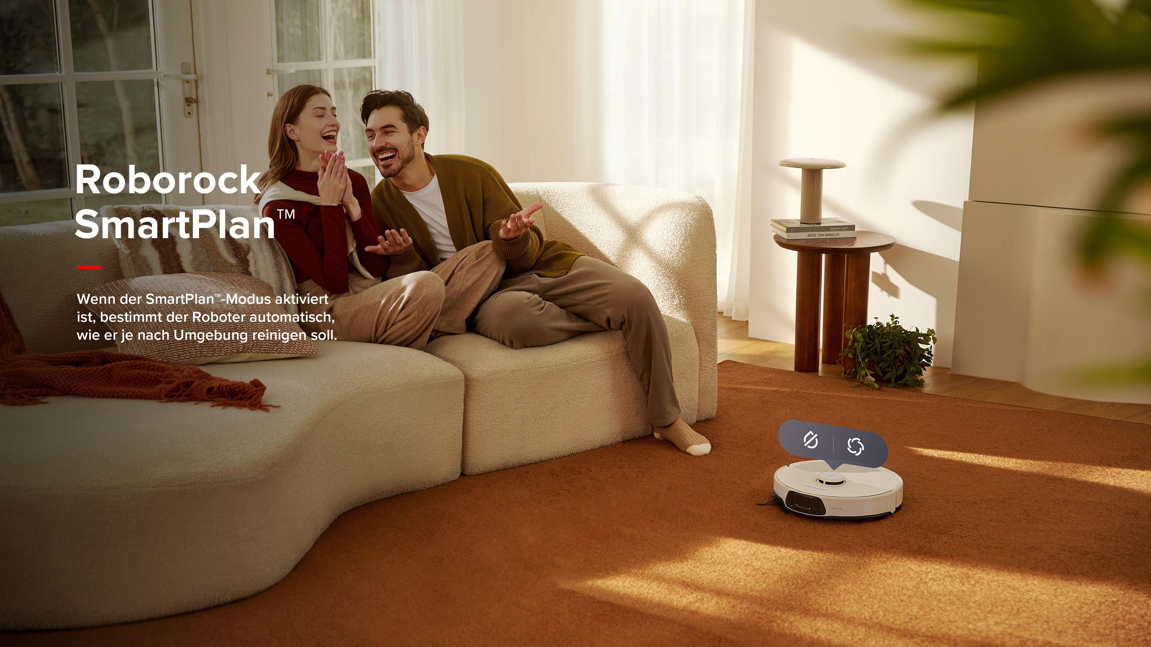 Ein Paar lacht, während ein Roboterstaubsauger den Boden reinigt. Der Text lautet SmartPlan.