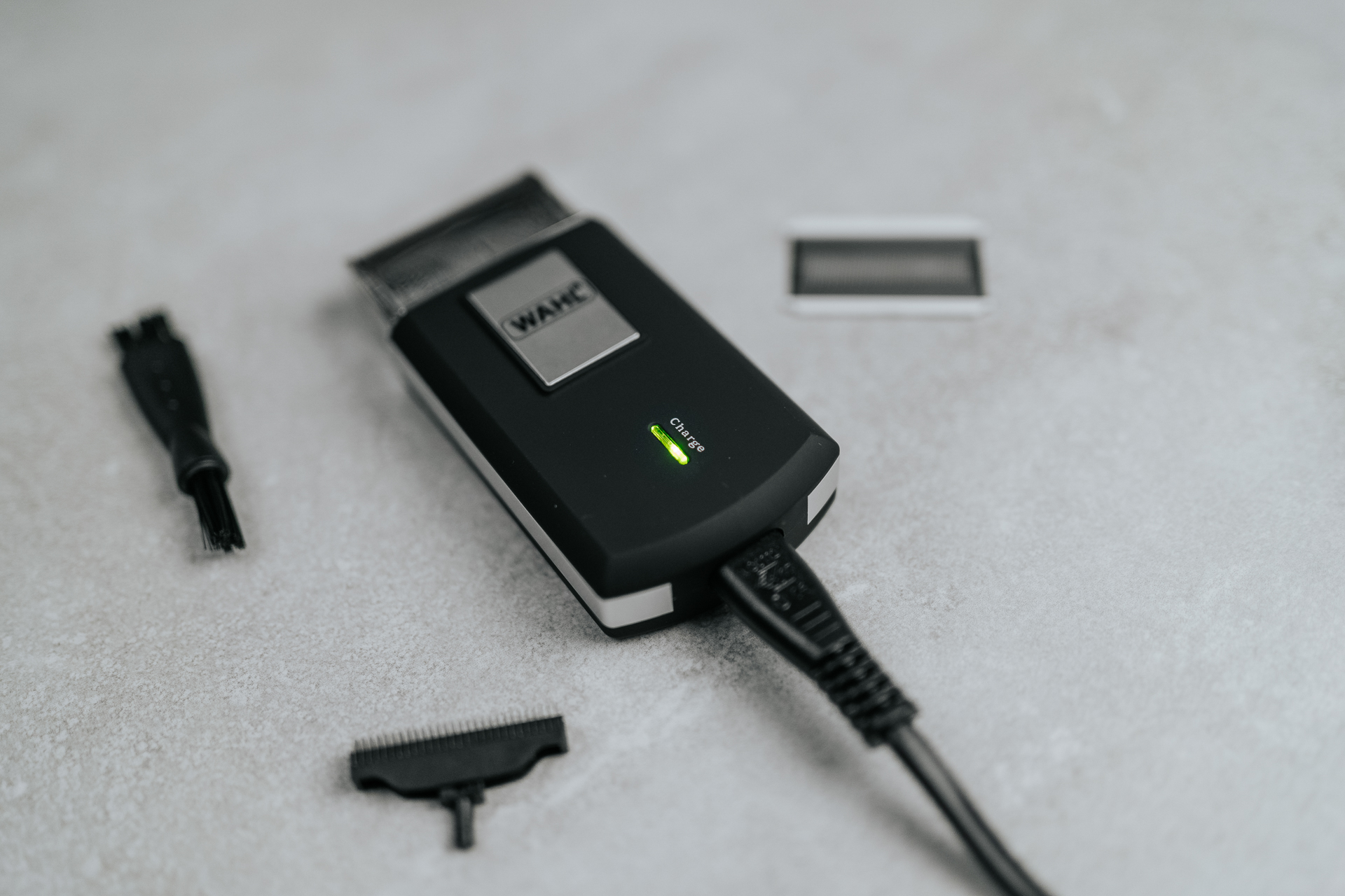 Fekete-ezüst elektromos hajvágó világos felületen.