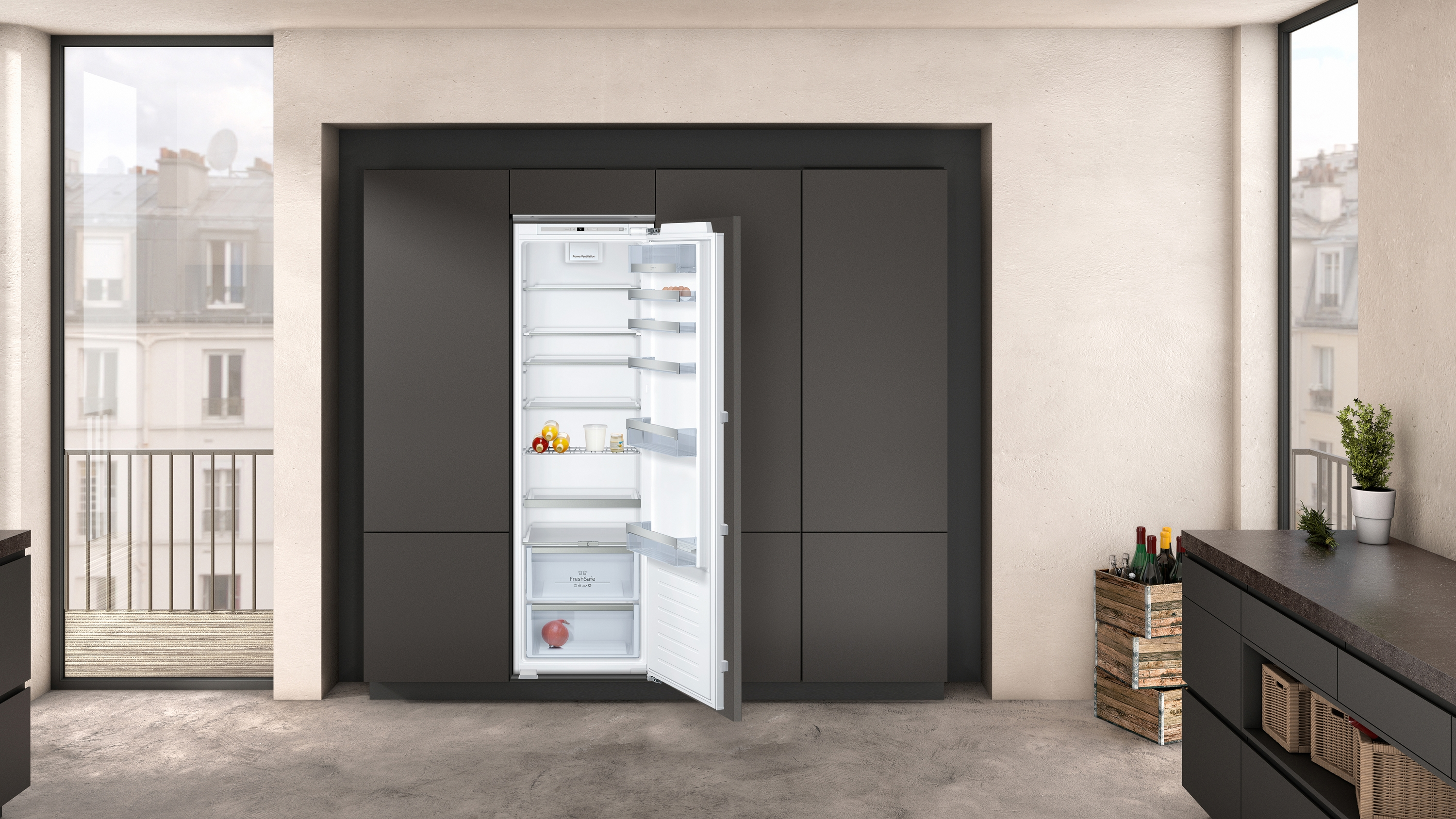Ein Kühlschrank ist in einer Küche geöffnet, mit Regalen voller Lebensmittel und einer Schublade mit Obst.