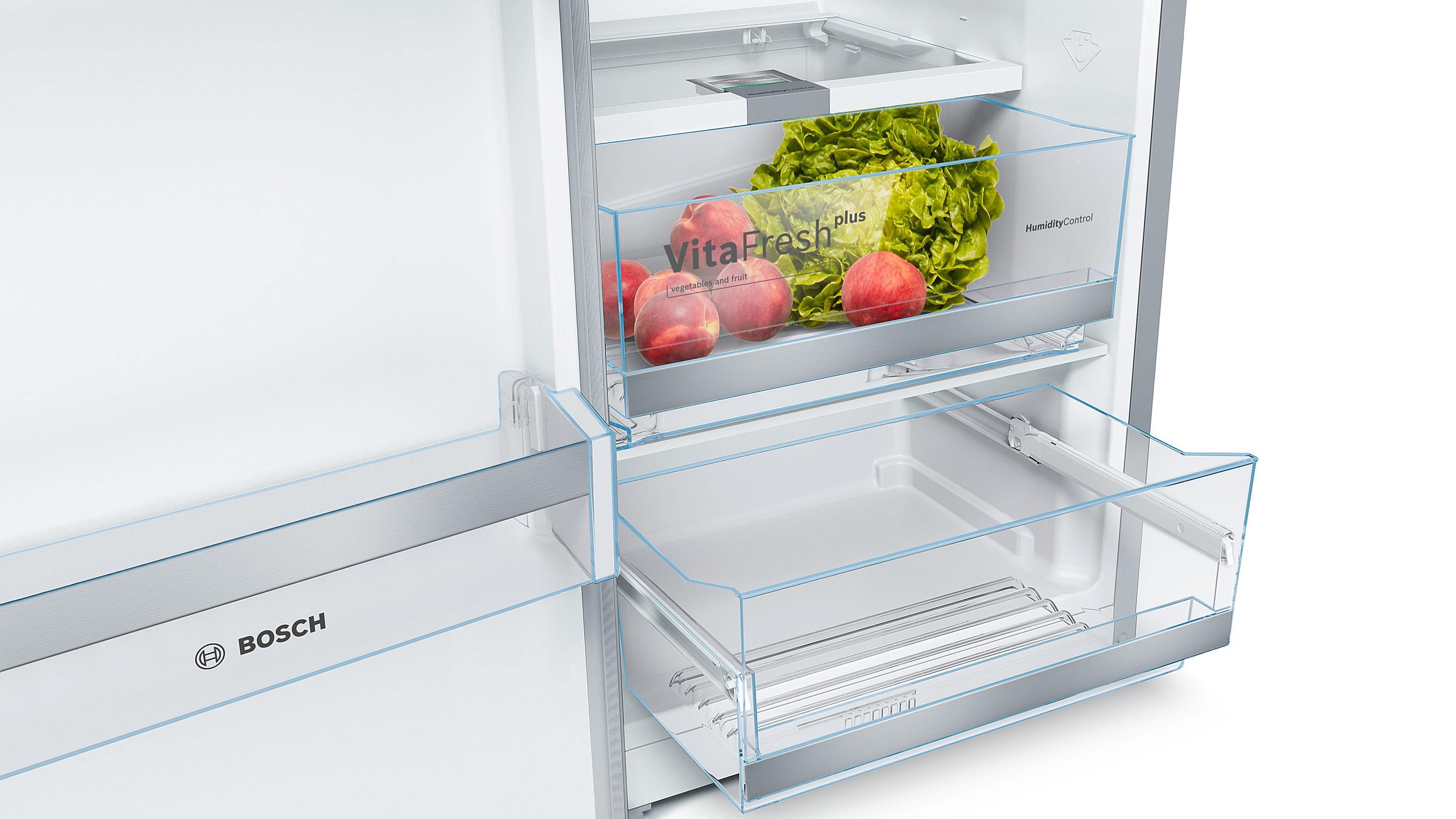 Intérieur de réfrigérateur avec fruits et légumes dans les tiroirs.