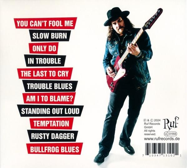 Musiker in Jeansjacke mit roter Gitarre, Album-Titelliste links.