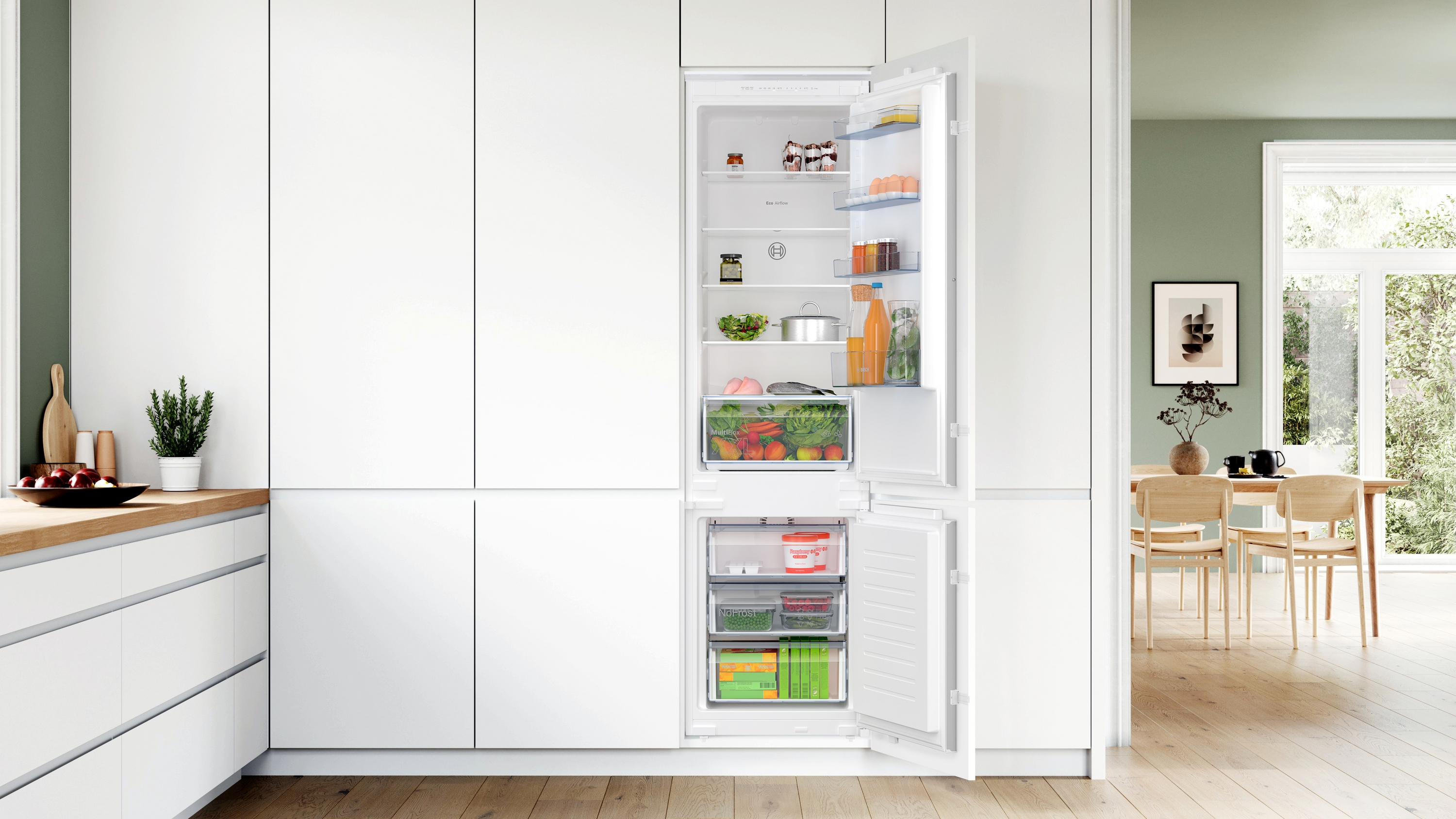 Weißer Kühlschrank mit offener Tür, der das Innere mit Lebensmitteln zeigt.