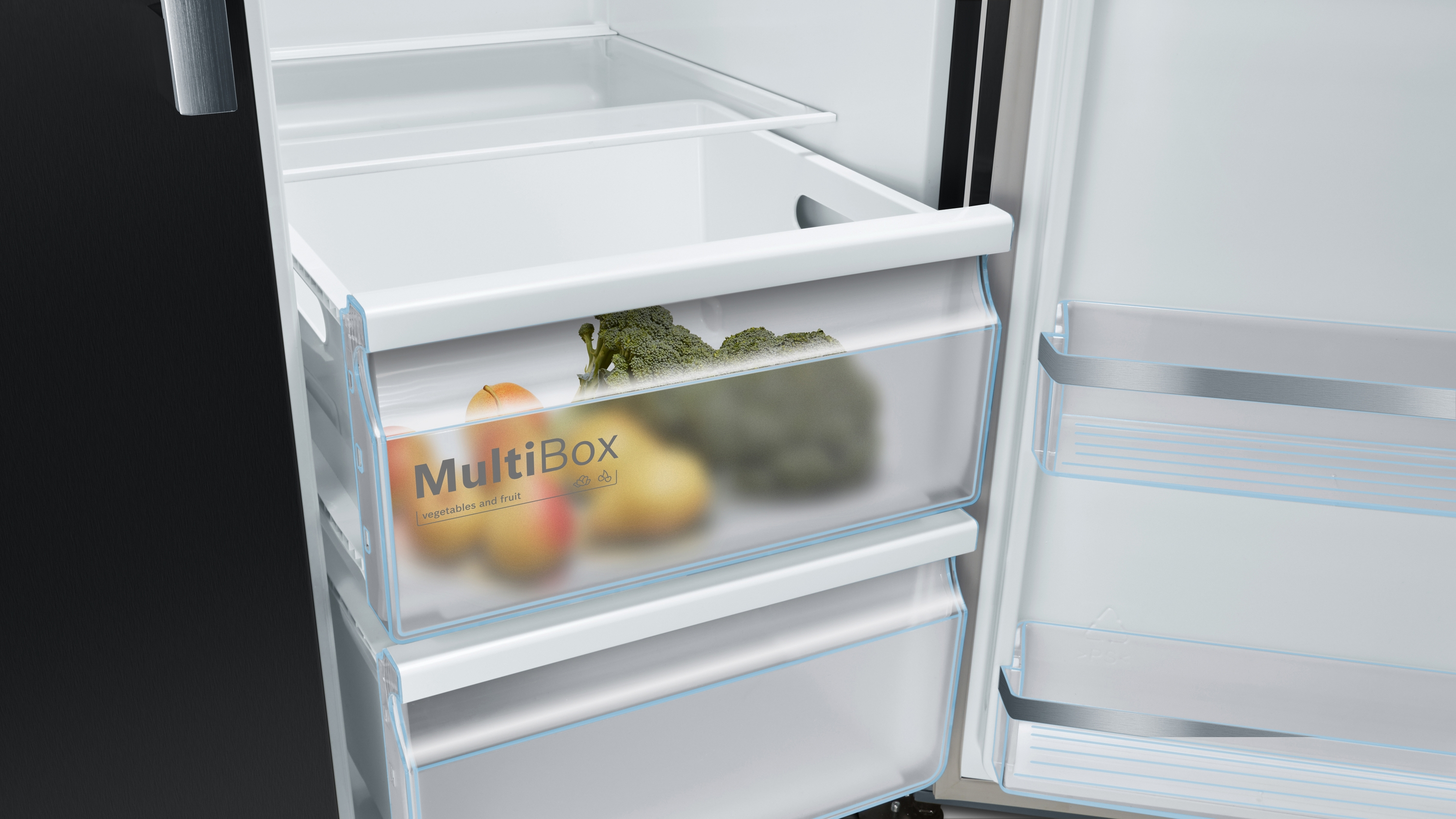 Kühlschrankinnenraum. Zwei transparente Schubladen mit Gemüse und Obst, beschriftet MultiBox.