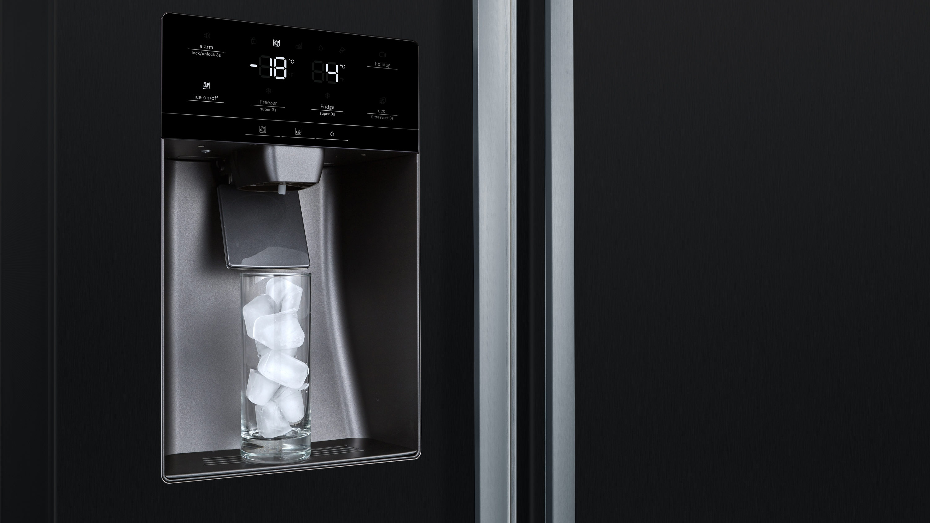 Eine Kühlschranktür mit Eisspender. Ein Glas fängt Eiswürfel auf. Display zeigt -18 und 4.