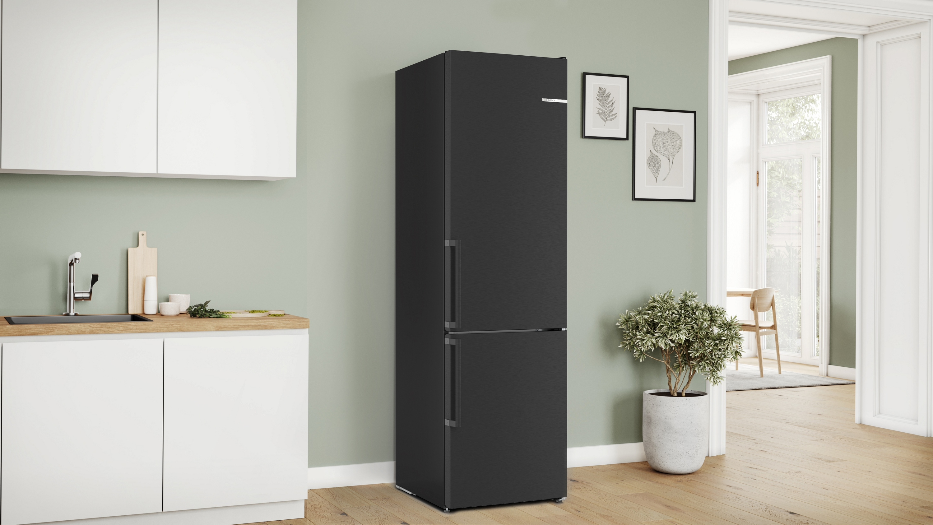 Schwarzer Kühlschrank mit weißen Arbeitsplatten und einer Pflanze im Raum.