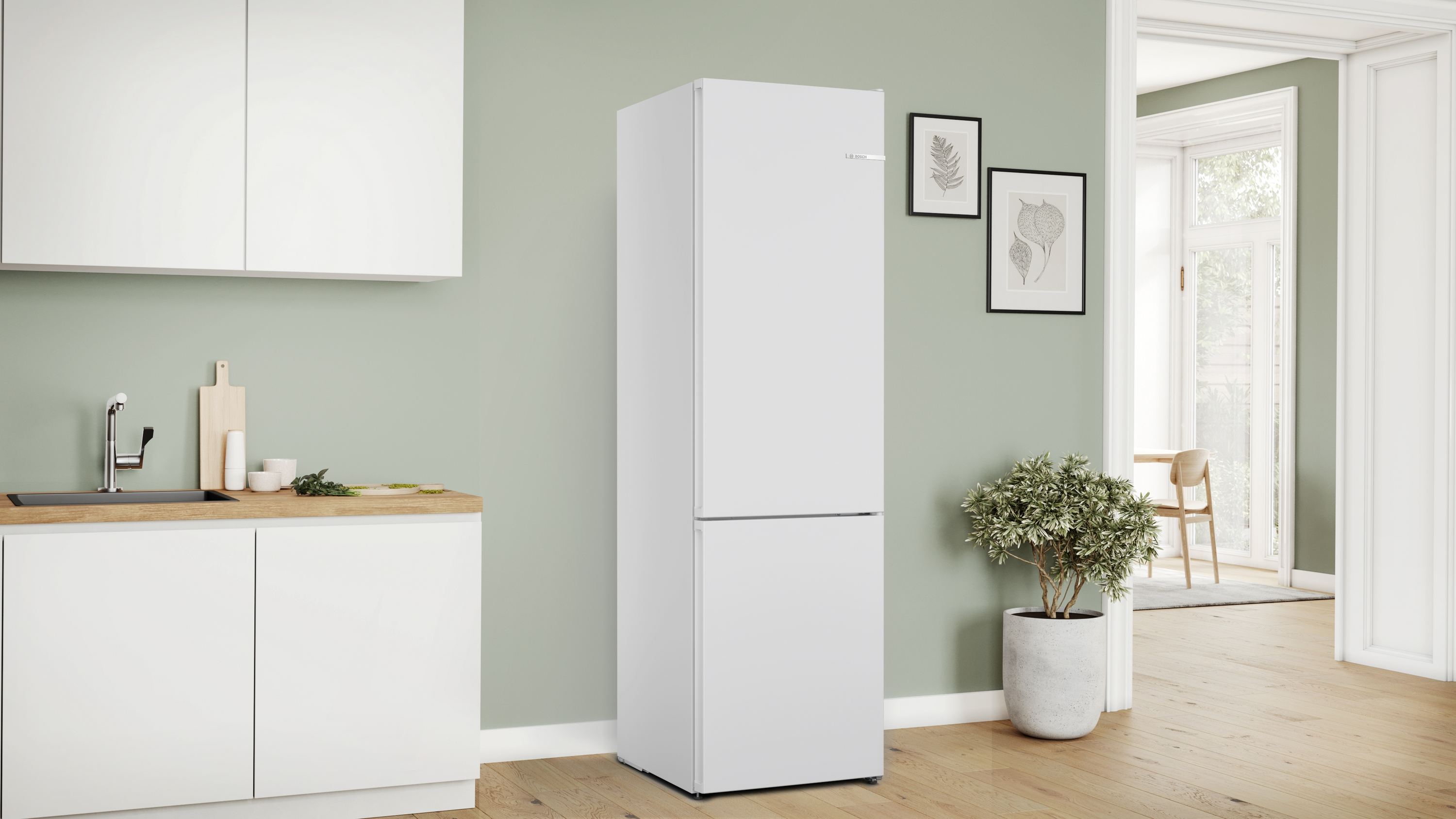 Ein weißer Kühlschrank in einer Küche mit grünen Wänden und Holz-Arbeitsplatte.