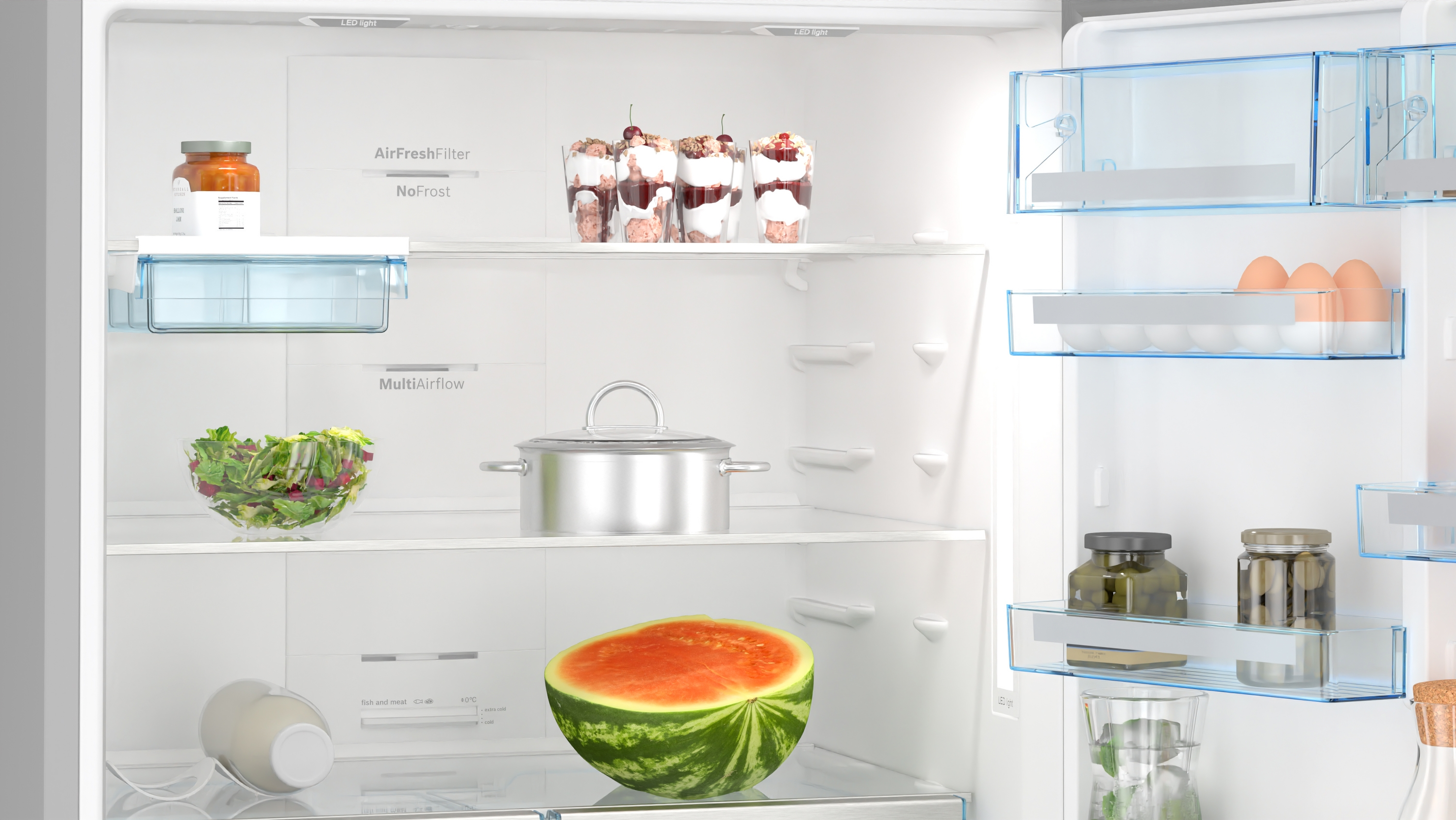 Im Inneren eines weißen Kühlschranks: Lebensmittel auf Regalen, einschließlich Wassermelone.