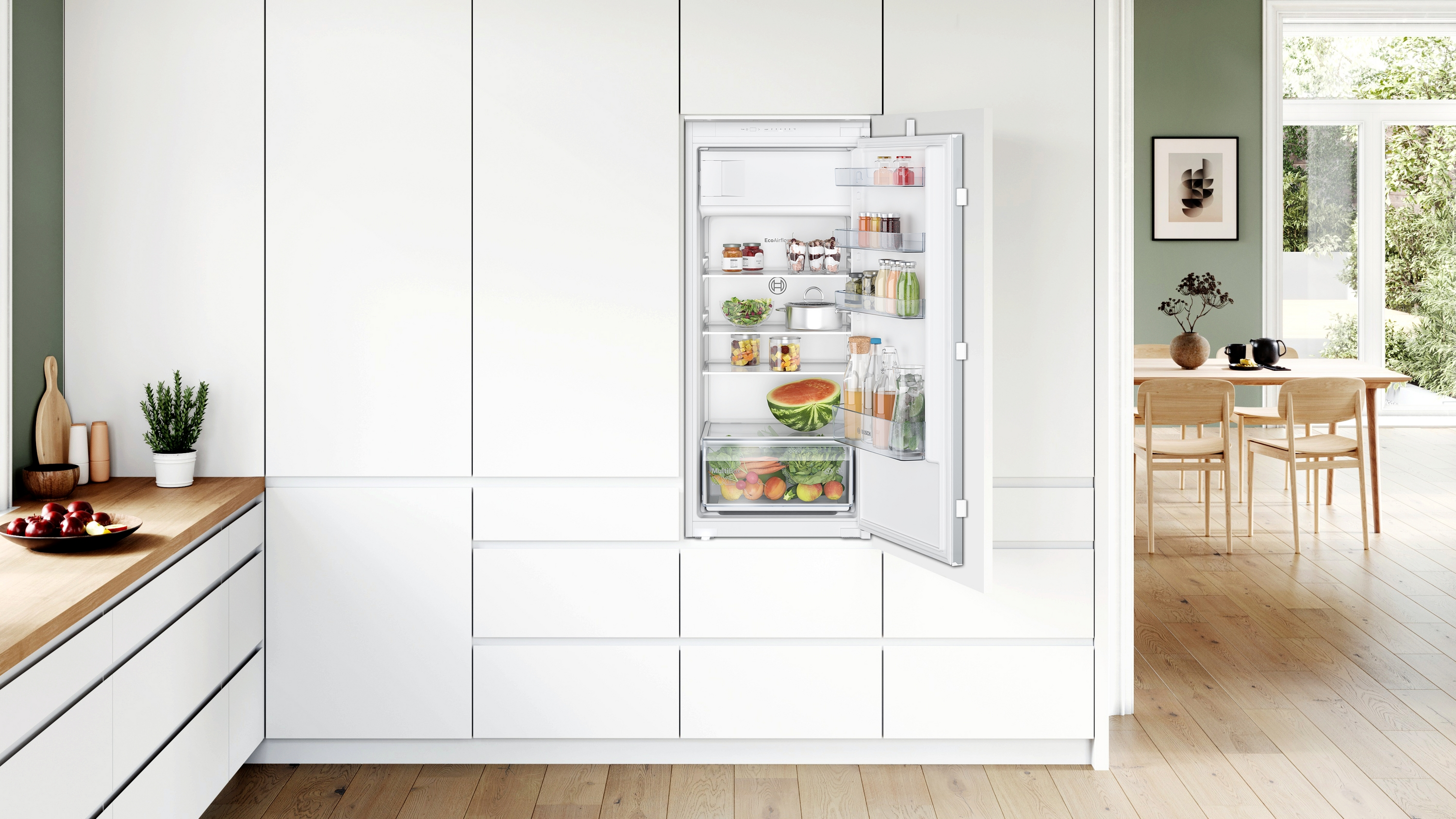 Eine moderne Küche mit weißem Kühlschrank, offen, mit Obst, Gemüse und Getränken.