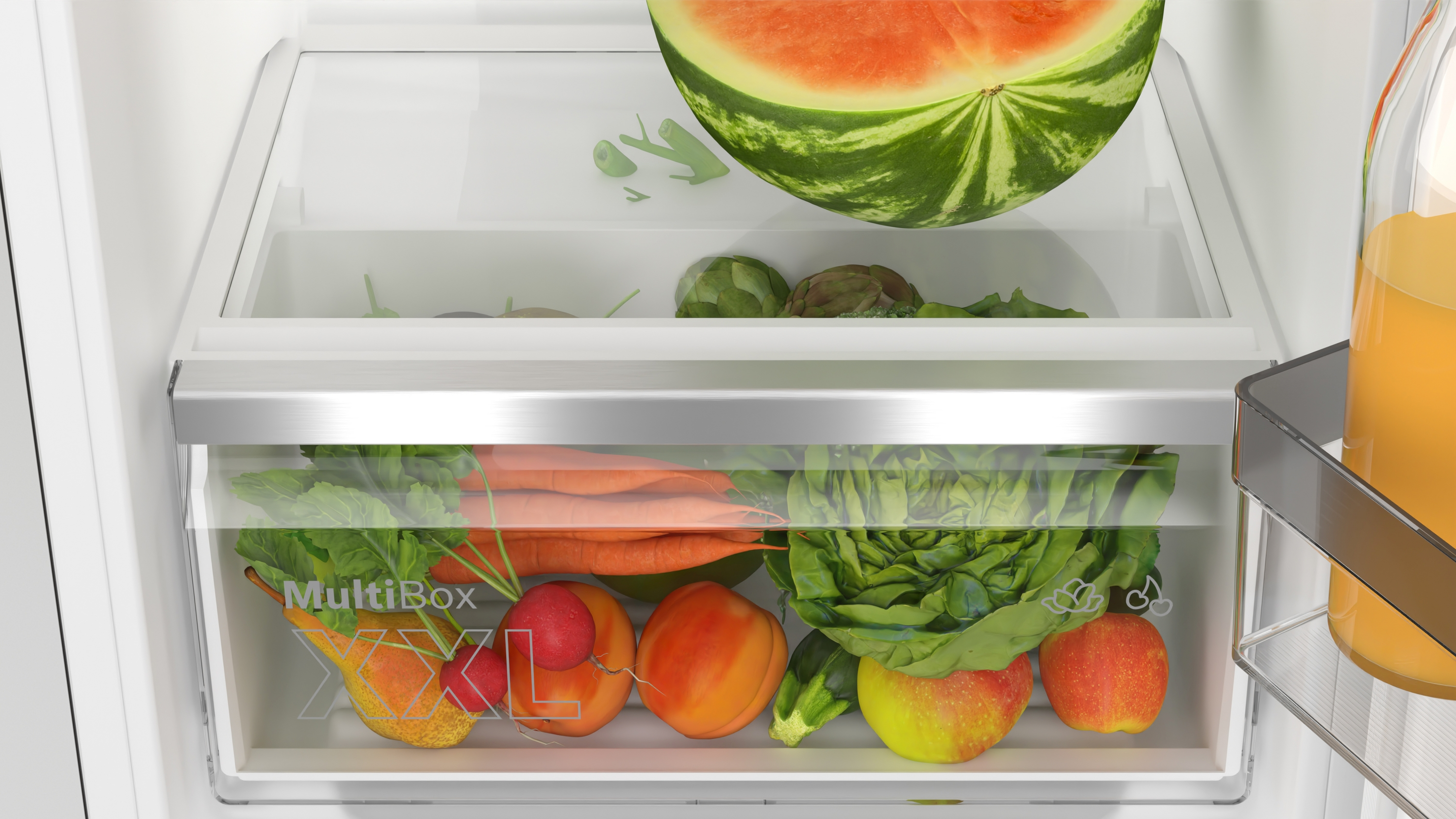 Kühlschublade gefüllt mit Gemüse und einer Wassermelone.