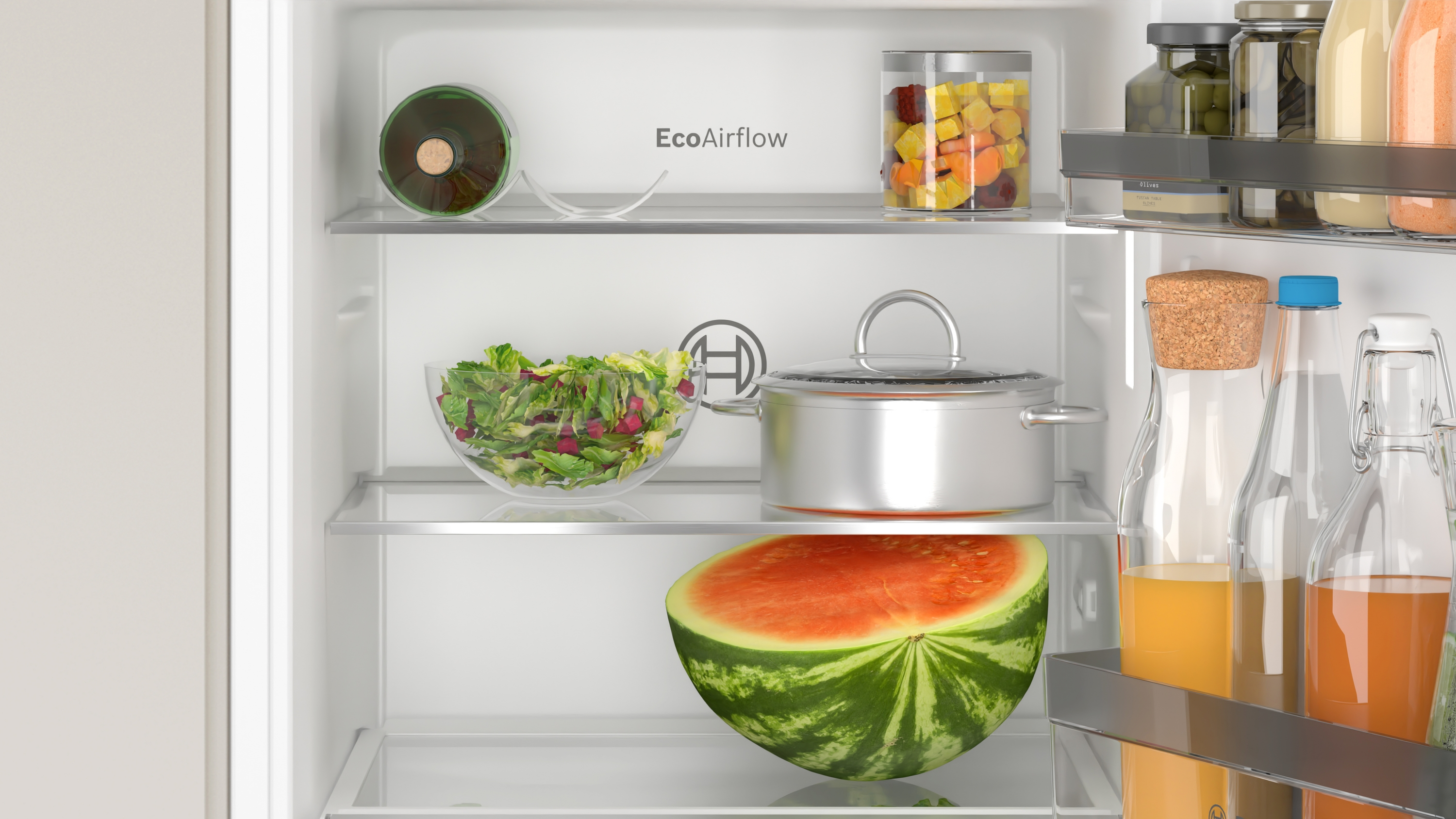 Kühlschrankinnenraum mit Regalen, die Wassermelone, Salat und andere Lebensmittel enthalten.