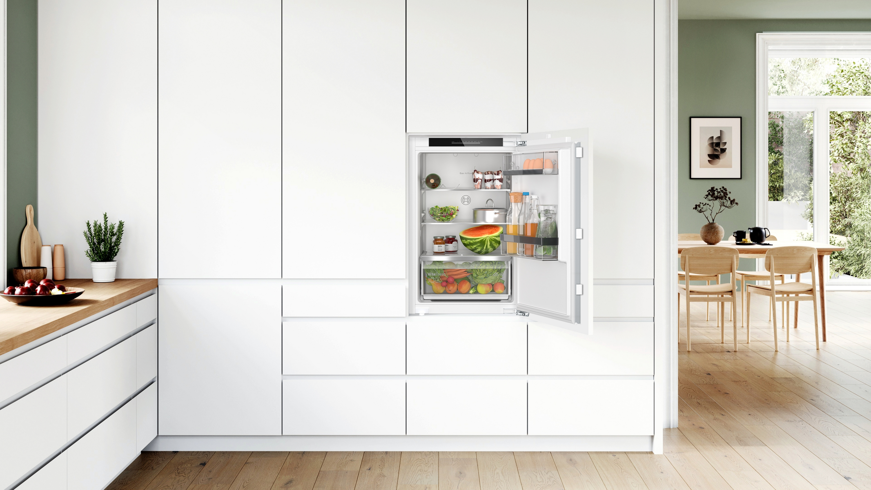 Moderne Küche mit weißen Schränken. Ein Kühlschrank ist geöffnet, zeigt Lebensmittel im Inneren.