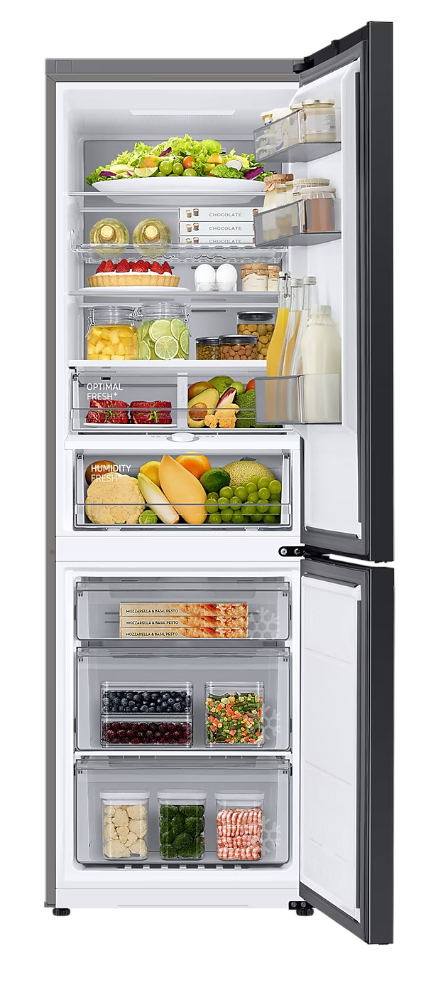 Otwarta lodówka. Jedzenie jest widoczne. Owoce, warzywa i pojemniki. Ciemnoszara obudowa.