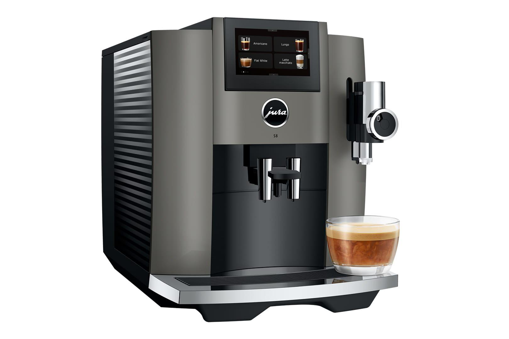 Graue Espressomaschine mit Glasbecher. Touchscreen, Markenname und Auslauf rechts.