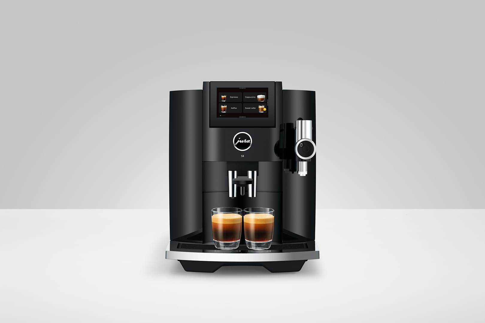 Schwarze Kaffeemaschine mit Touchscreen, zwei Espressotassen. Marke Jura.