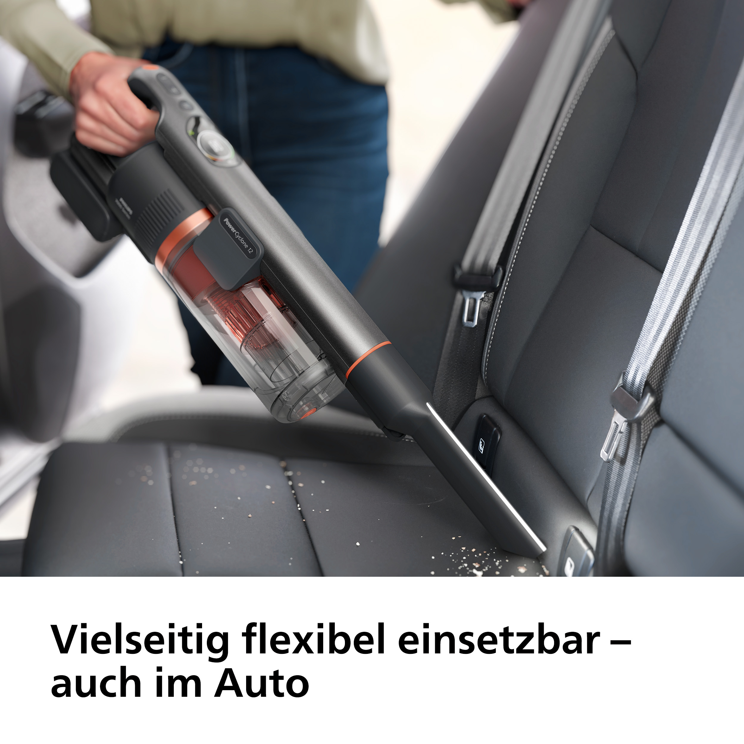 Person mit Handstaubsauger, der einen Autositz reinigt, im Auto.