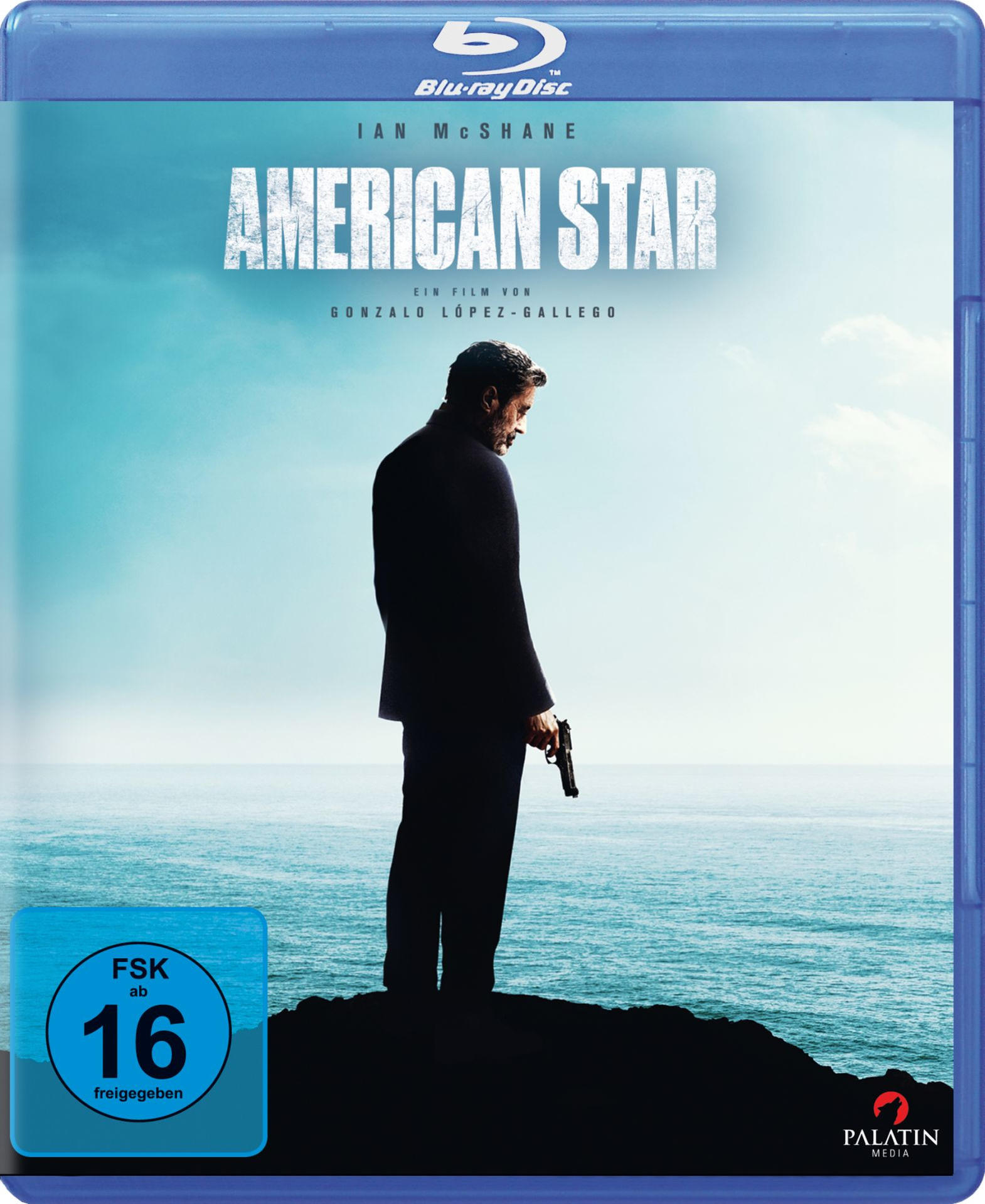 Blu-ray-Hülle. Ein Mann im Anzug mit einer Waffe steht am Strand.