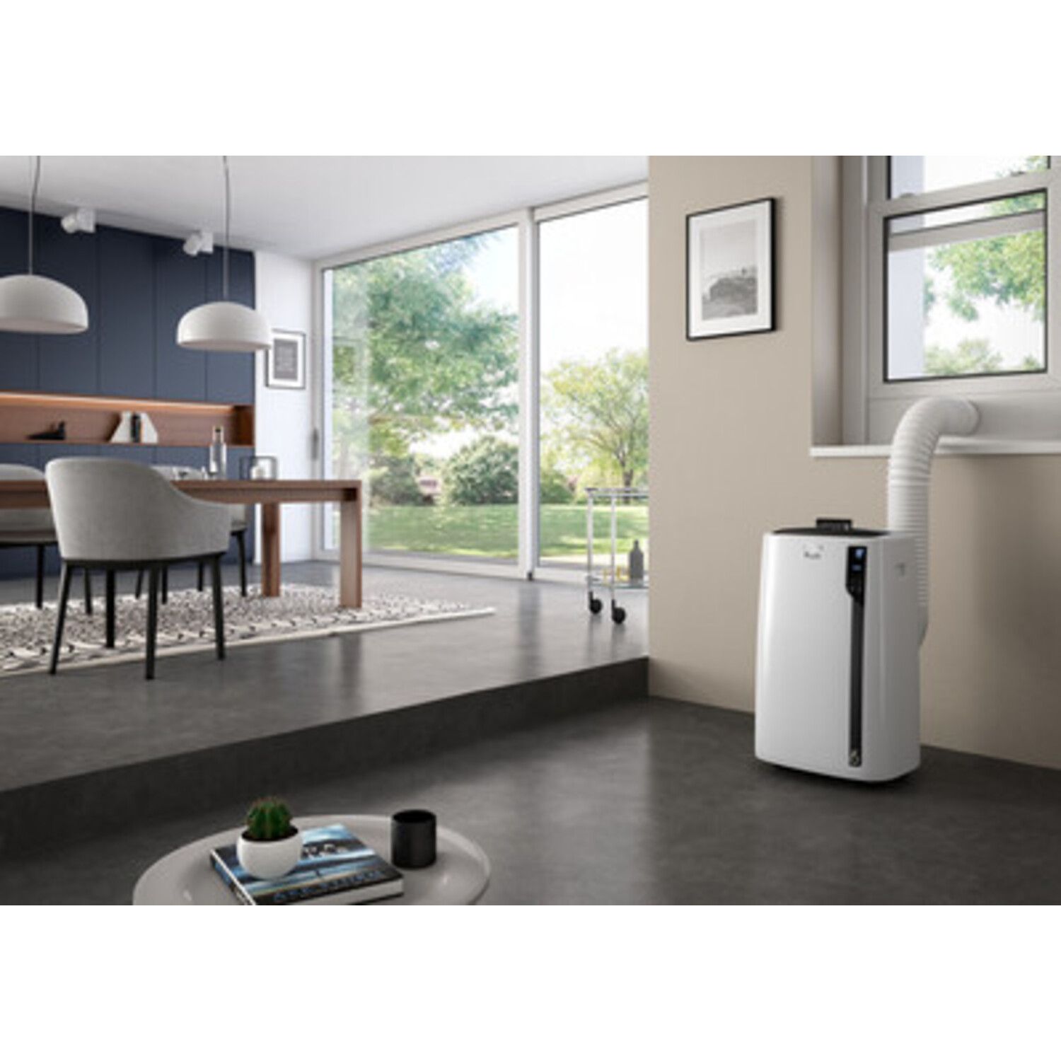 Salon moderne avec un climatiseur portable blanc. Grandes fenêtres montrent un extérieur vert.