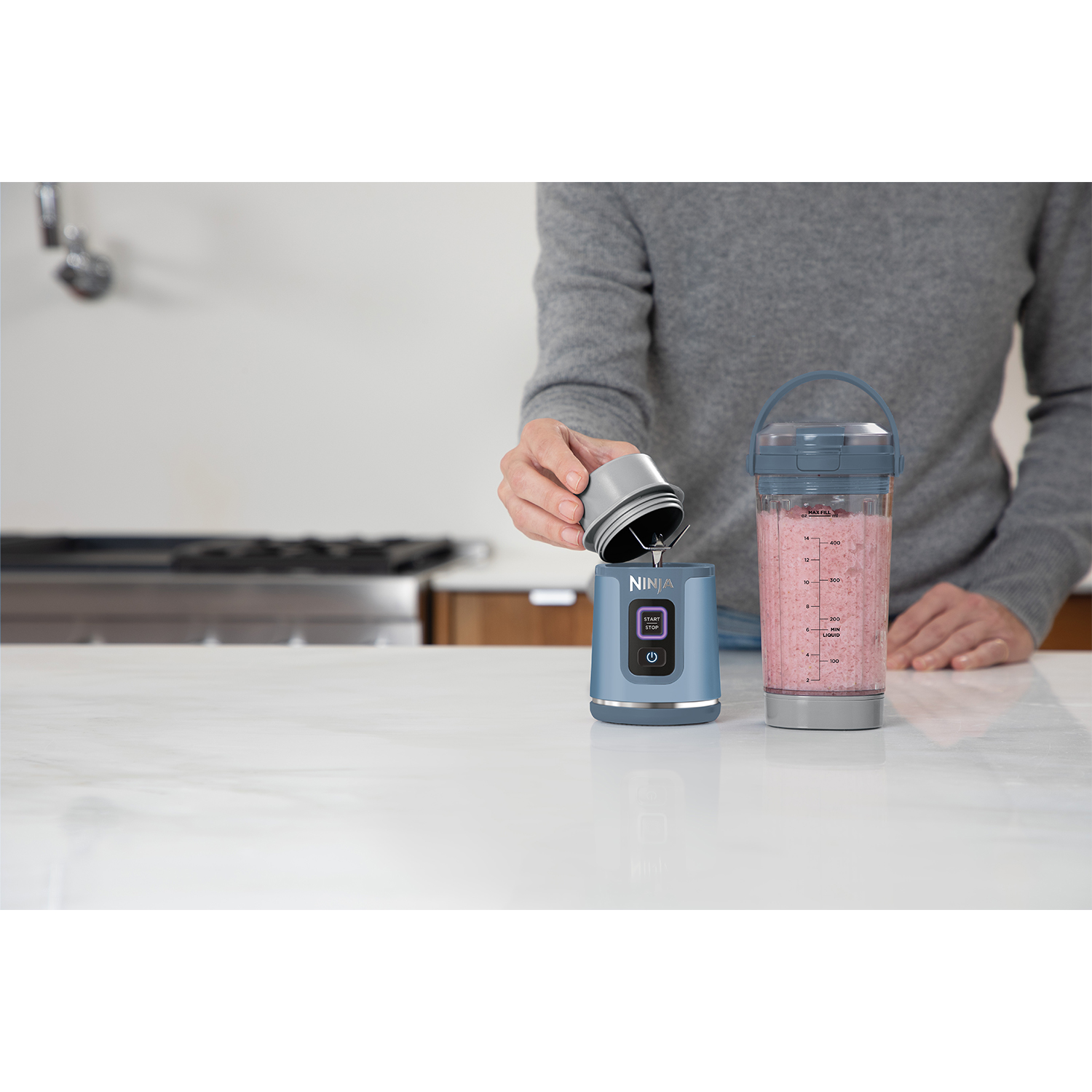 Una persona versa ingredienti in un frullatore blu.
