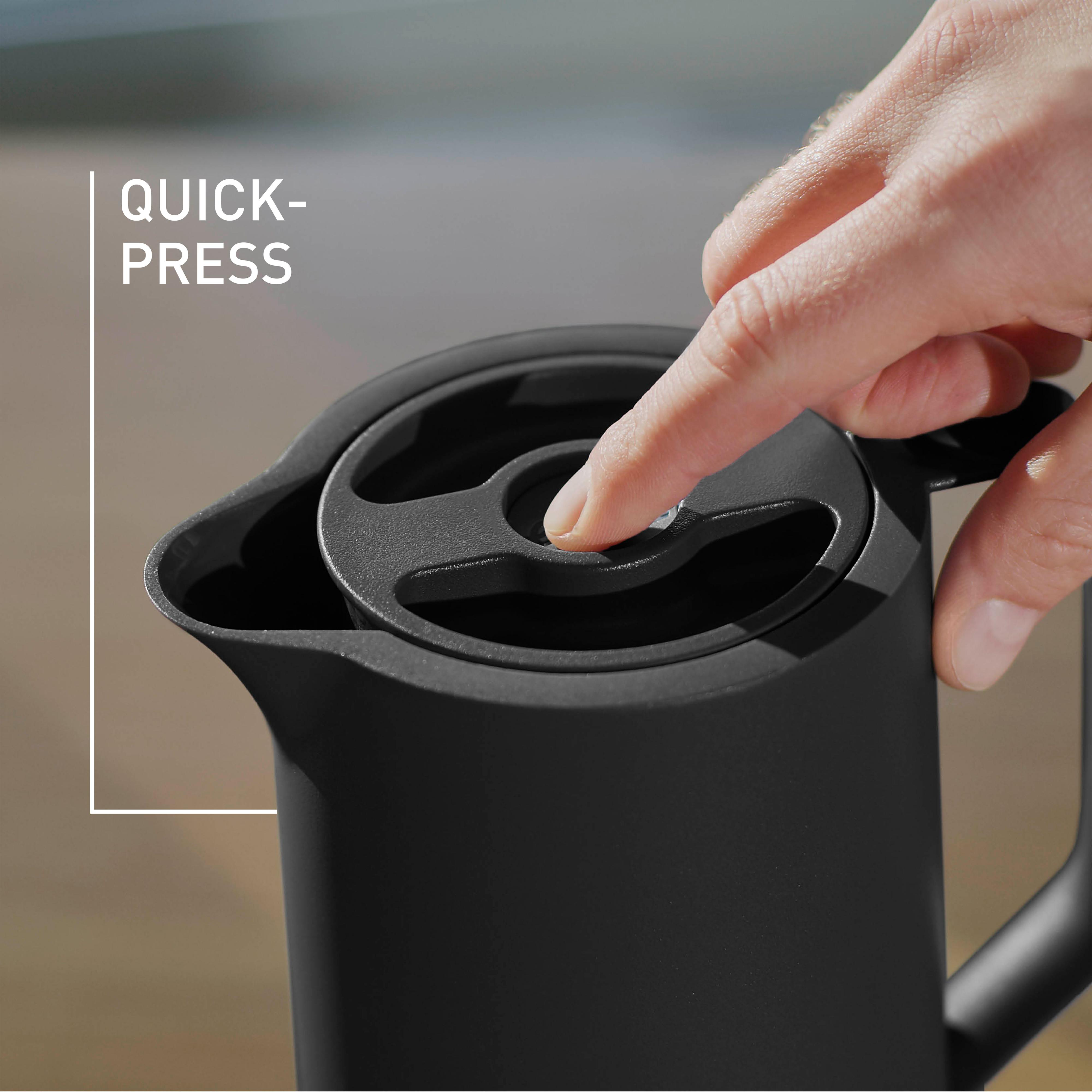 Nahaufnahme einer schwarzen Thermoskanne mit einem Finger, der den Schnell-Druck-Knopf am Deckel drückt.